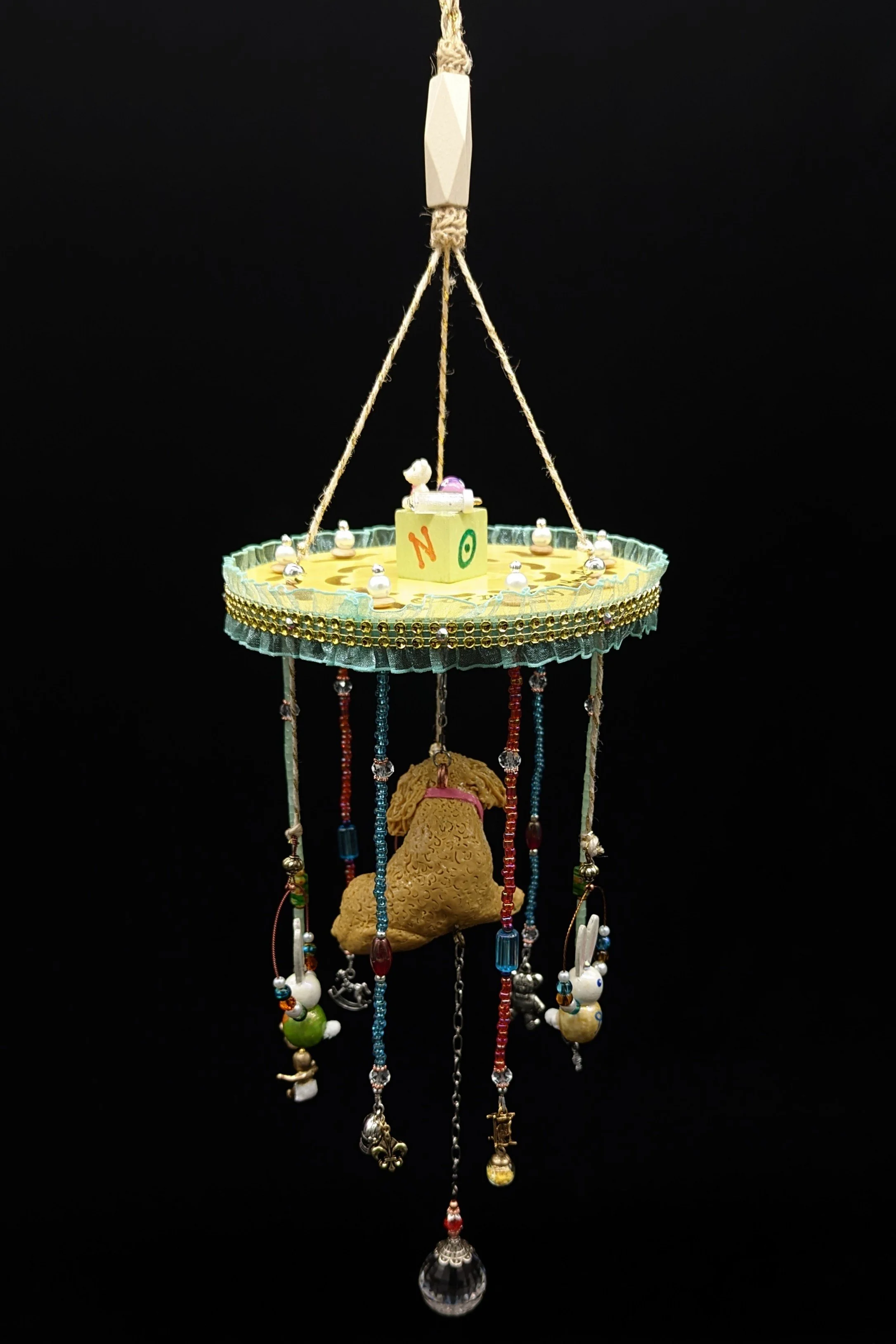 Rear view of the Puppy Commission Mobile by Art Illusions by Young. Measuring approximately 6.5” wide by 18” long, the mobile features the hand-sculpted polymer clay Puppy, painted building block with family name topped with a miniature teddy, rattle