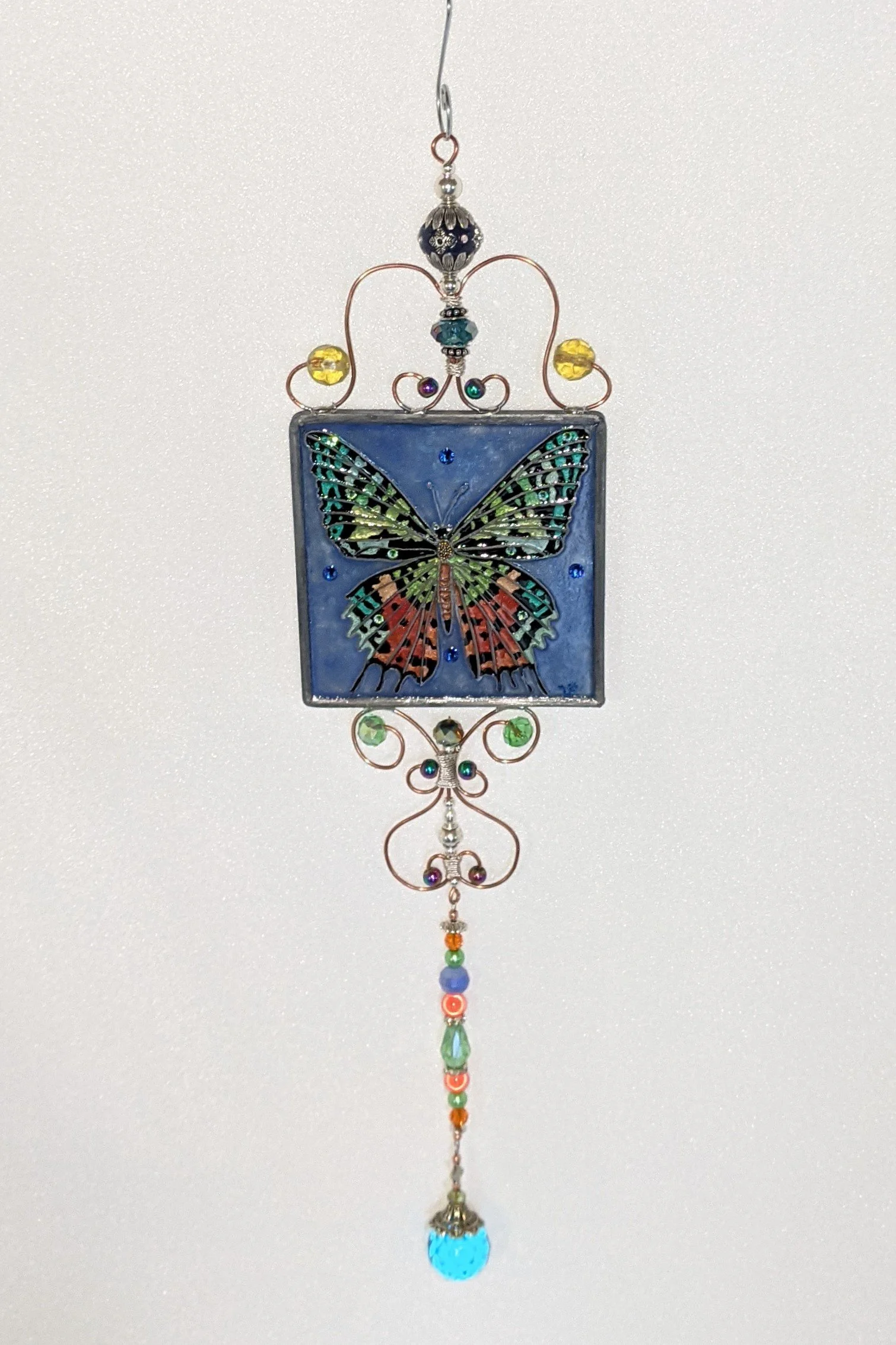 🔴 Sold: 
Butterfly Illusion Glass by Art Illusions by Young. A delicate square suncatcher showcasing a graceful butterfly with intricately patterned wings in soft, glowing colors. The piece captures the ephemeral beauty of nature through hand-painte