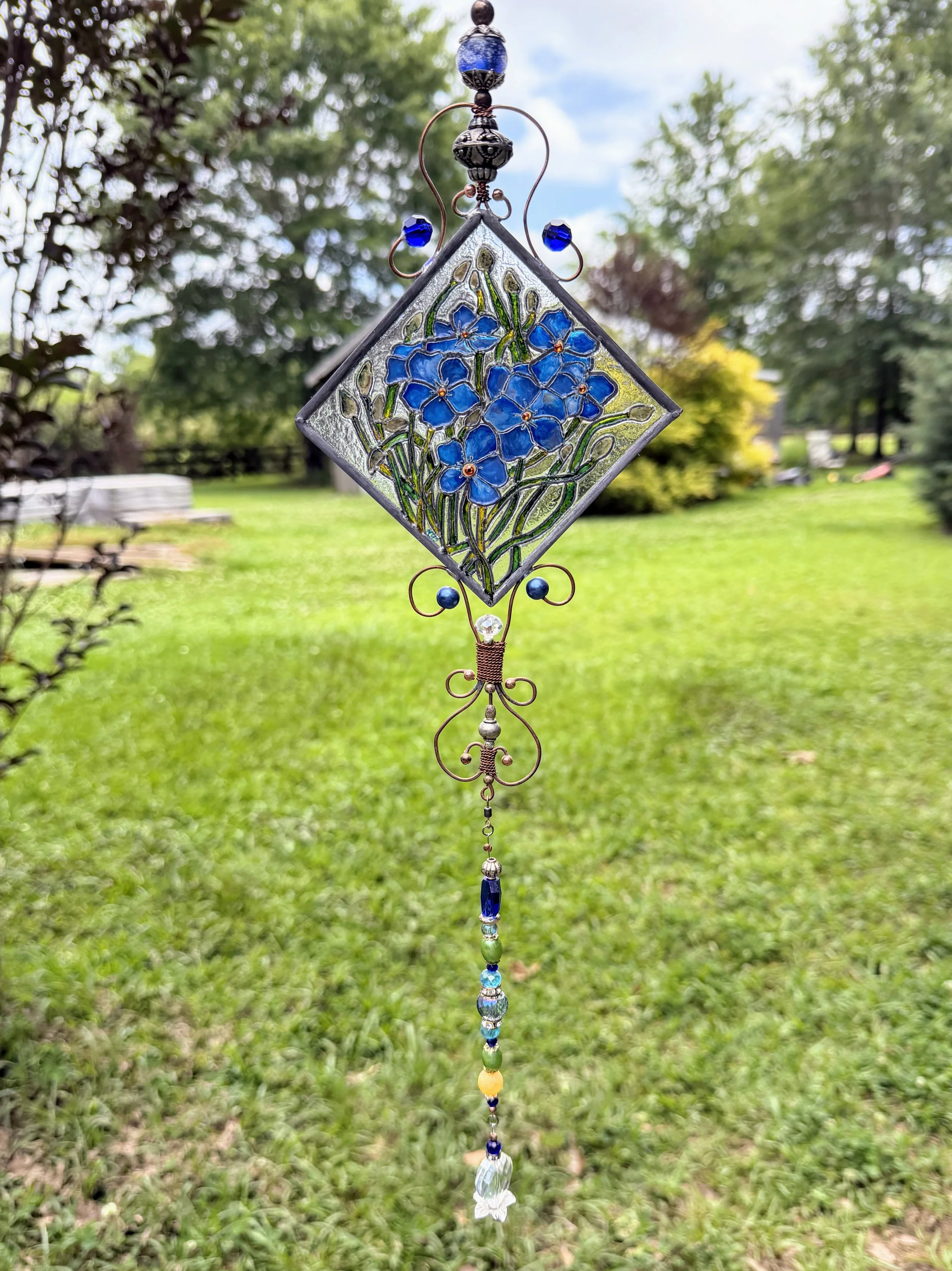 Forget-Me-Nots by Art Illusions by Young. A delicate cluster of vibrant blue forget-me-not flowers blooms eternally in this hand-painted and leaded Illusion Glass panel. Soft blue petals with golden centers and gentle green foliage are rendered with 