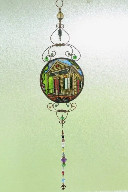 🔴 Sold: 
New Orleans Shotgun House Illusion Glass by Art Illusions by Young. This charming circular suncatcher captures the iconic architecture of a colorful New Orleans shotgun house with detailed gingerbread trim and vibrant facade. It glows with 