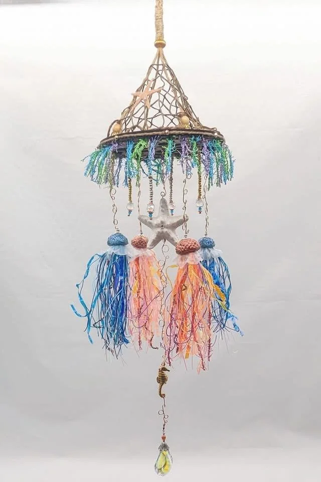 Jellyfish Mobiles – Chihuly-Inspired Light Catcher by Art Illusions by Young from Folsom, Louisiana. This luminous art mobile features a decorative and authentic netted canopy — sisal-wrapped and suspended from a walnut laser-cut wooden disc — formin