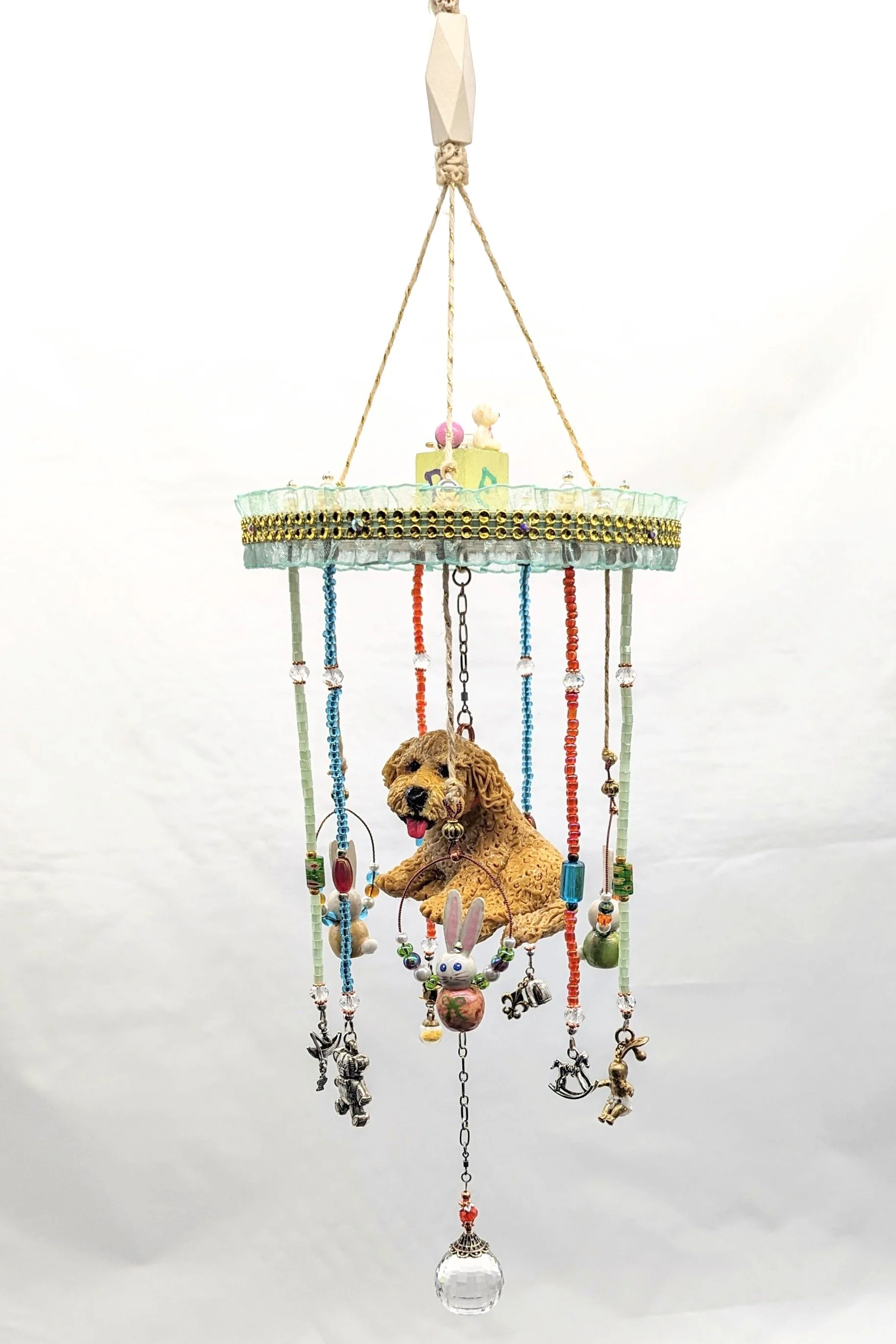 🔴 Sold: 
Cherished Puppy Mobile by Art Illusions by Young, Folsom, Louisiana. A sweet nursery mobile featuring a hand-sculpted or detailed puppy seated on a swing, surrounded by flowing multicolored ribbons and dangling charms. The wooden top bar an