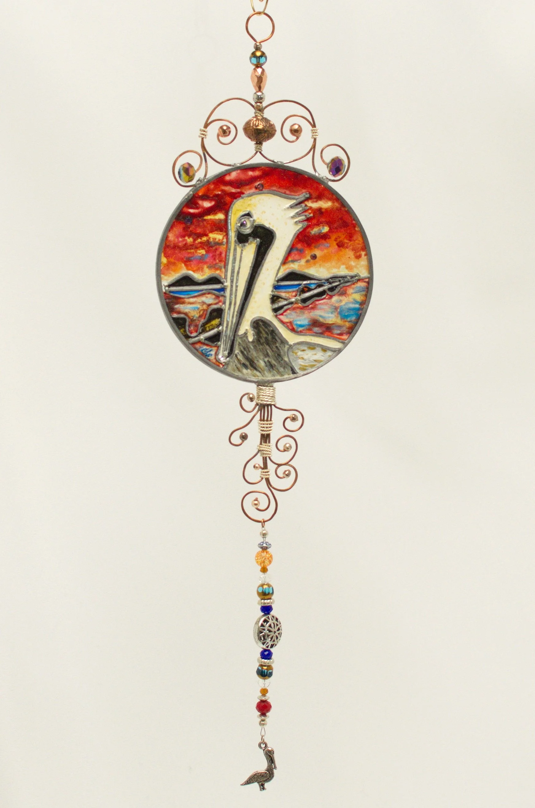 🔴 Sold: 
Brown Pelican Illusion Glass by Art Illusions by Young. A majestic brown pelican sits near coastal waters, against a soft sky, in this round suncatcher. The realistic details and subtle color layering bring Louisiana’s iconic seabird to lum