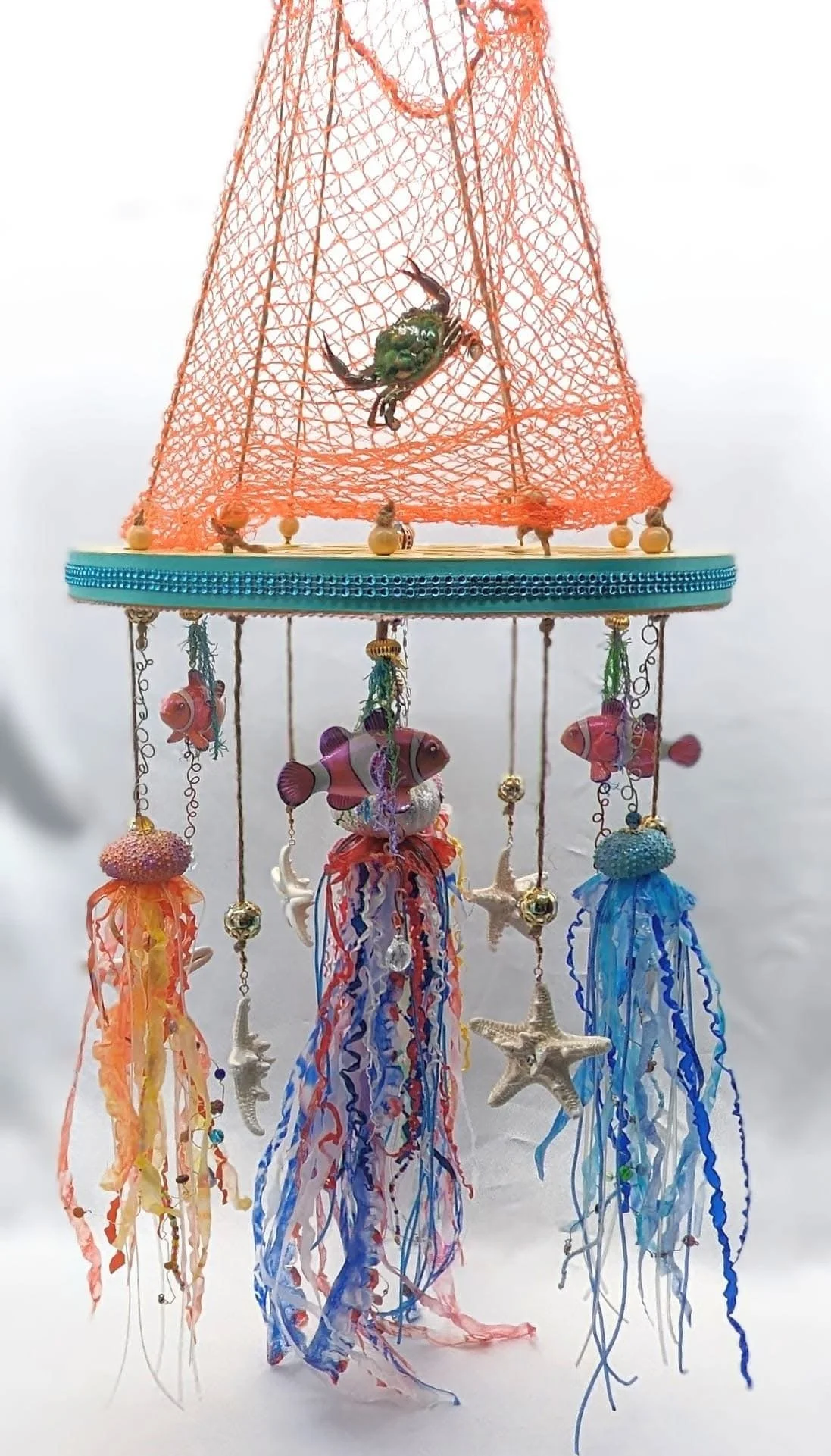 Nautical Jellyfish Mobile – Ocean Wonder for the Nursery by Art Illusions by Young from Folsom, Louisiana. This extra-large custom mobile features a unique scrollwork wooden hanger suspending a decorative and authentic netted canopy. Beneath it drift