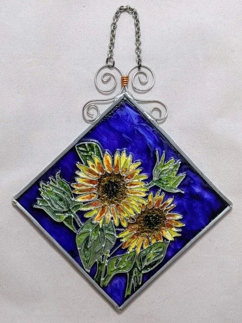 🔴 Sold: 
Sunflowers Illusion Glass by Art Illusions by Young. Delicate white and yellow daisies fill this bright diagonal suncatcher, rendered with soft, painterly strokes and sparkling accents. The fresh, uplifting composition creates a gentle lumi