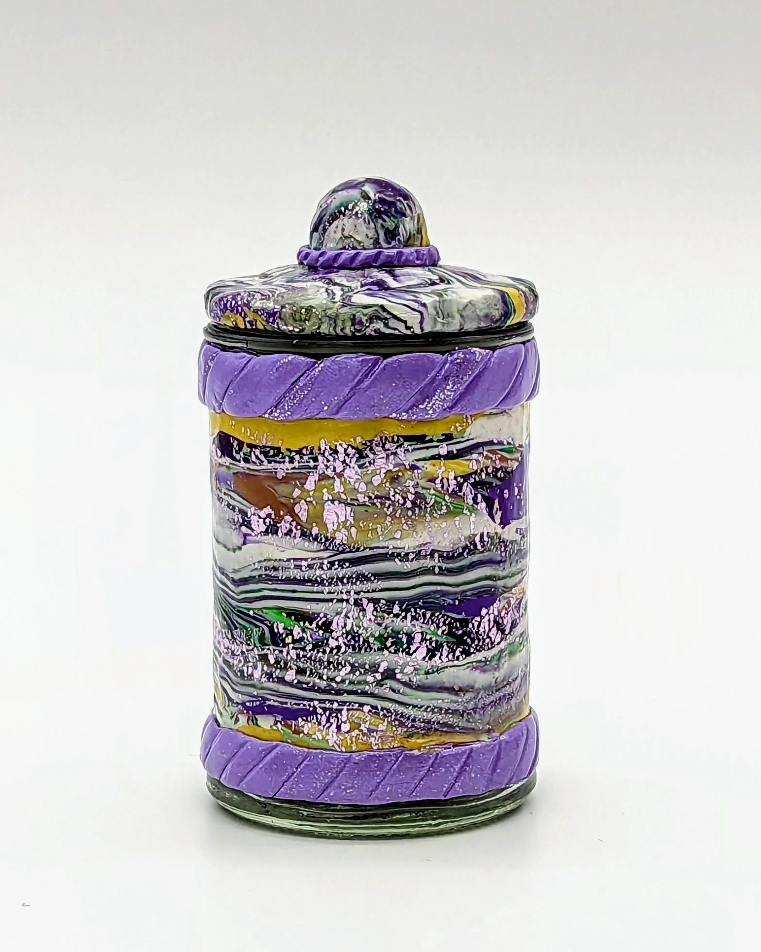 Mardi Gras Majesty Lidded Jar by Art Illusions by Young, Folsom, Louisiana. This hand-sculpted polymer clay vessel features rich swirling strata of deep purple, gold, white, lavender, and subtle green with bold purple rope-twist bands at the top and 