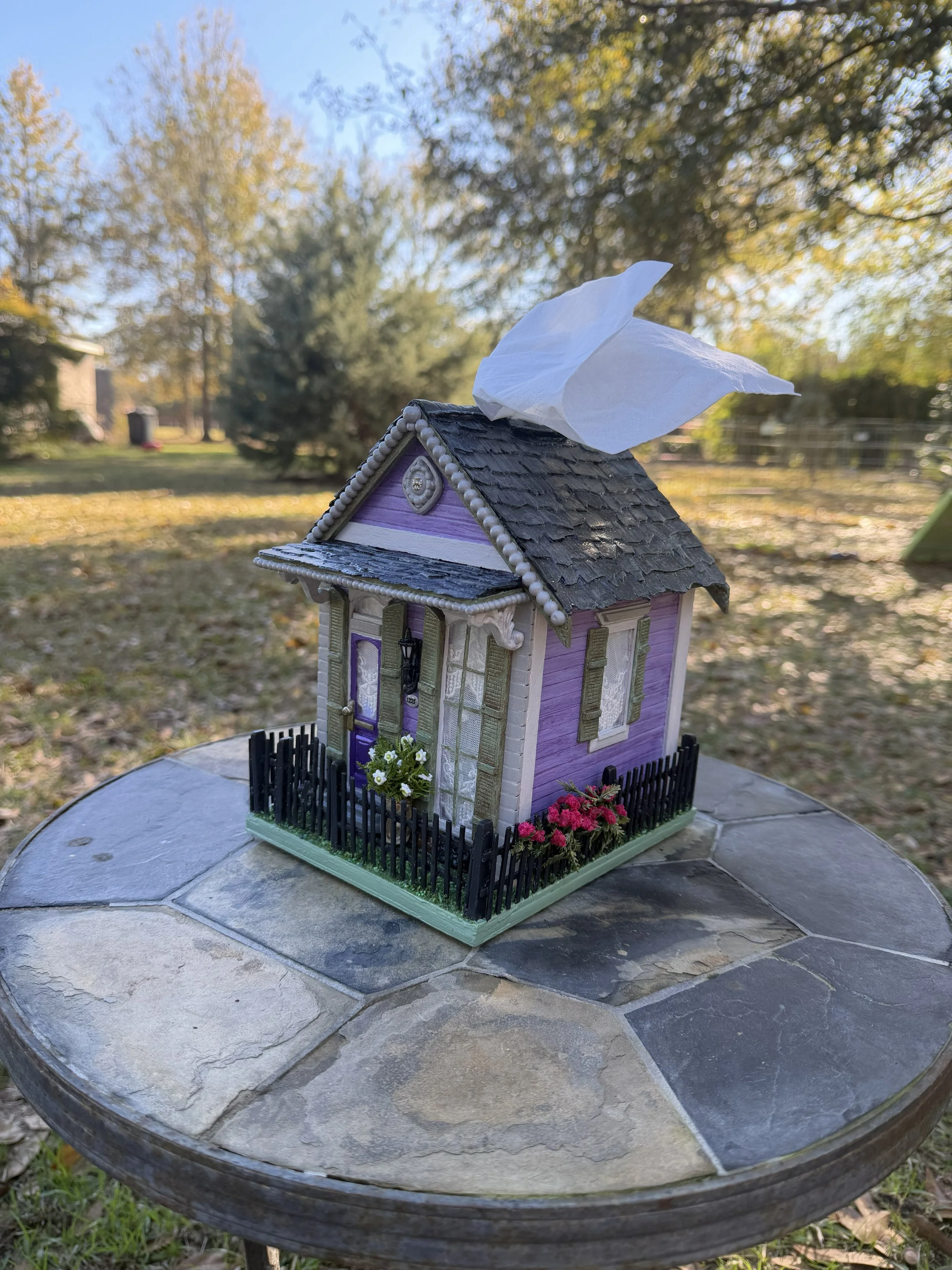 Handcrafted Purple Reign Shotgun House Tissue box cover diorama by Art Illusions by Young in Folsom, Louisiana. Lavender Creole-style shotgun house with ornate gingerbread trim, sage green shutters, and handmade wooden "wrought iron" fence displayed 