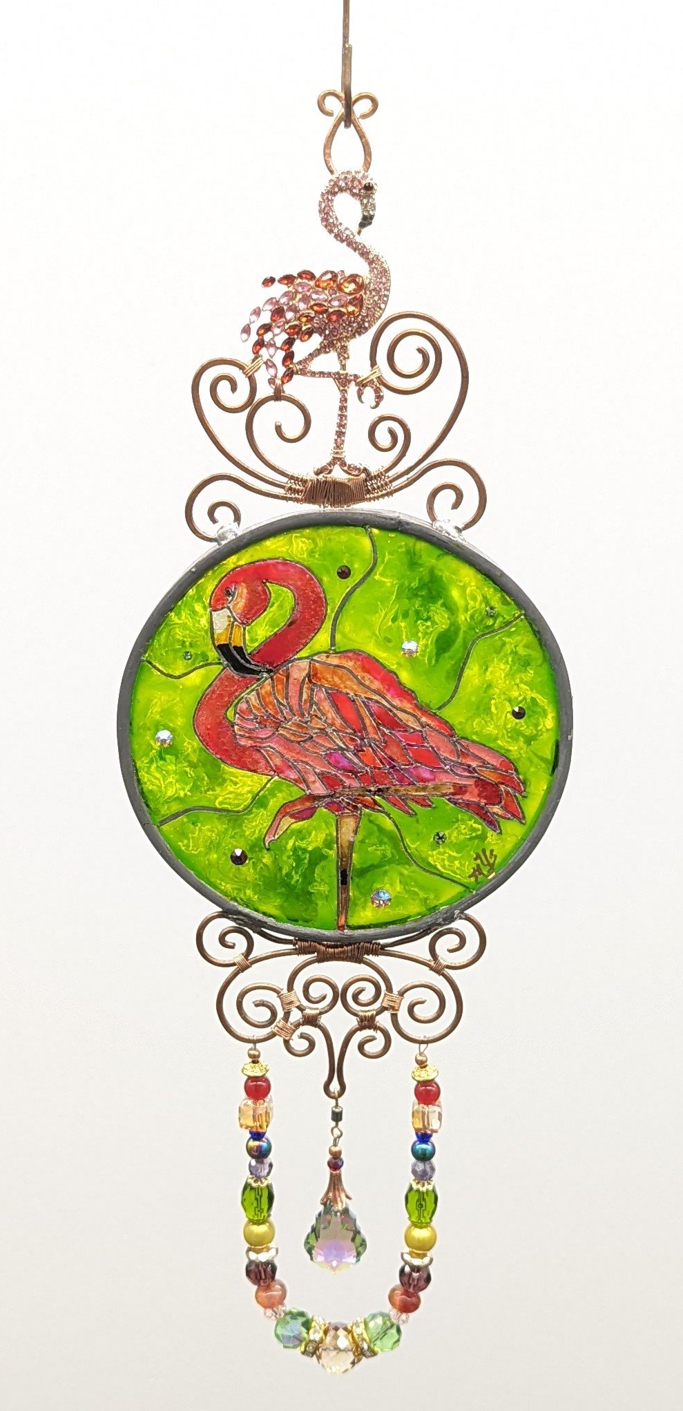 🔴 Sold: 
Flamingo Illusion Glass by Art Illusions by Young, Folsom, Louisiana. This graceful circular suncatcher features a vibrant pink flamingo standing elegantly against a lush green background. Hand-painted with European glass paints on leaded g