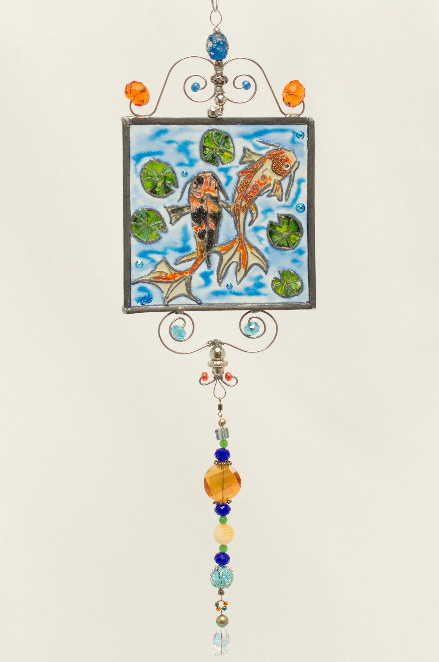 Fantail Koi Pond by Art Illusions by Young. Two graceful fantail koi swim serenely among lily pads in this hand-painted and leaded Illusion Glass panel. Their flowing, multicolored tails in vibrant shades of orange, red, white, and black create elega