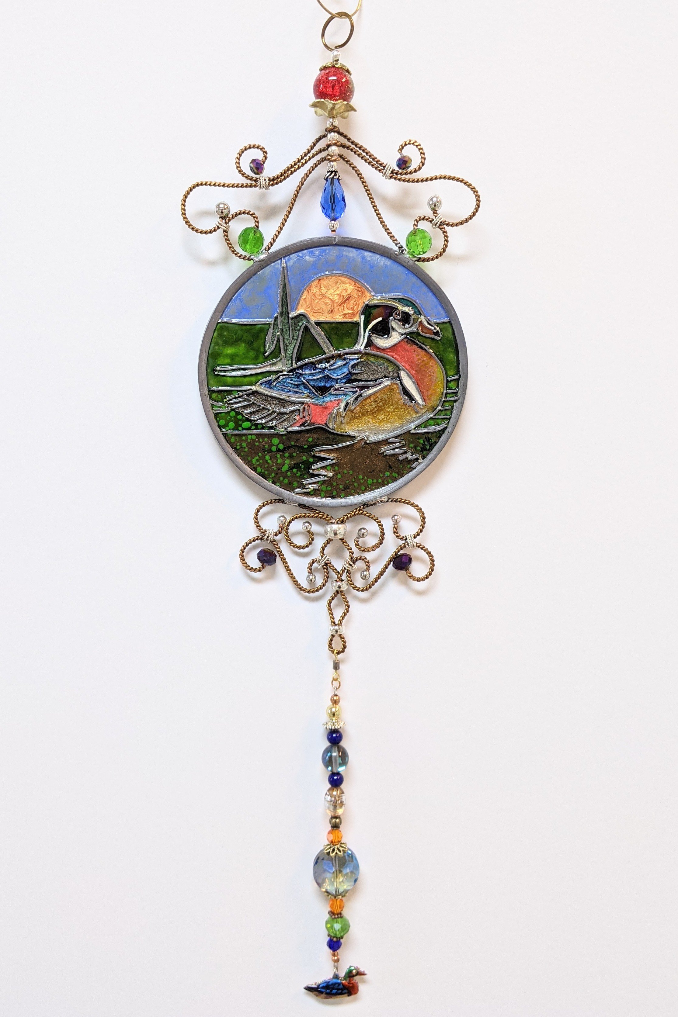Wood Duck by Art Illusions by Young. A handsome wood duck glides gracefully among cattails and reeds in this hand-painted and leaded Illusion Glass panel. The male’s striking iridescent plumage—rich greens, deep chestnuts, and crisp white markings—is