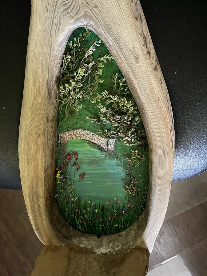 Finished painted interior view of the Enchanted City Park Serenity diorama showing the miniature pond, bridge, and abundant greenery inside the hollow tree trunk. Handcrafted by Art Illusions by Young.