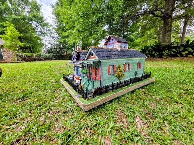 Right-side view of the handcrafted Triple New Orleans Shotgun House Row diorama by Art Illusions by Young. This angle beautifully showcases the soft sage green shotgun house with striking persimmon orange shutters, ornate gingerbread trim, detailed s