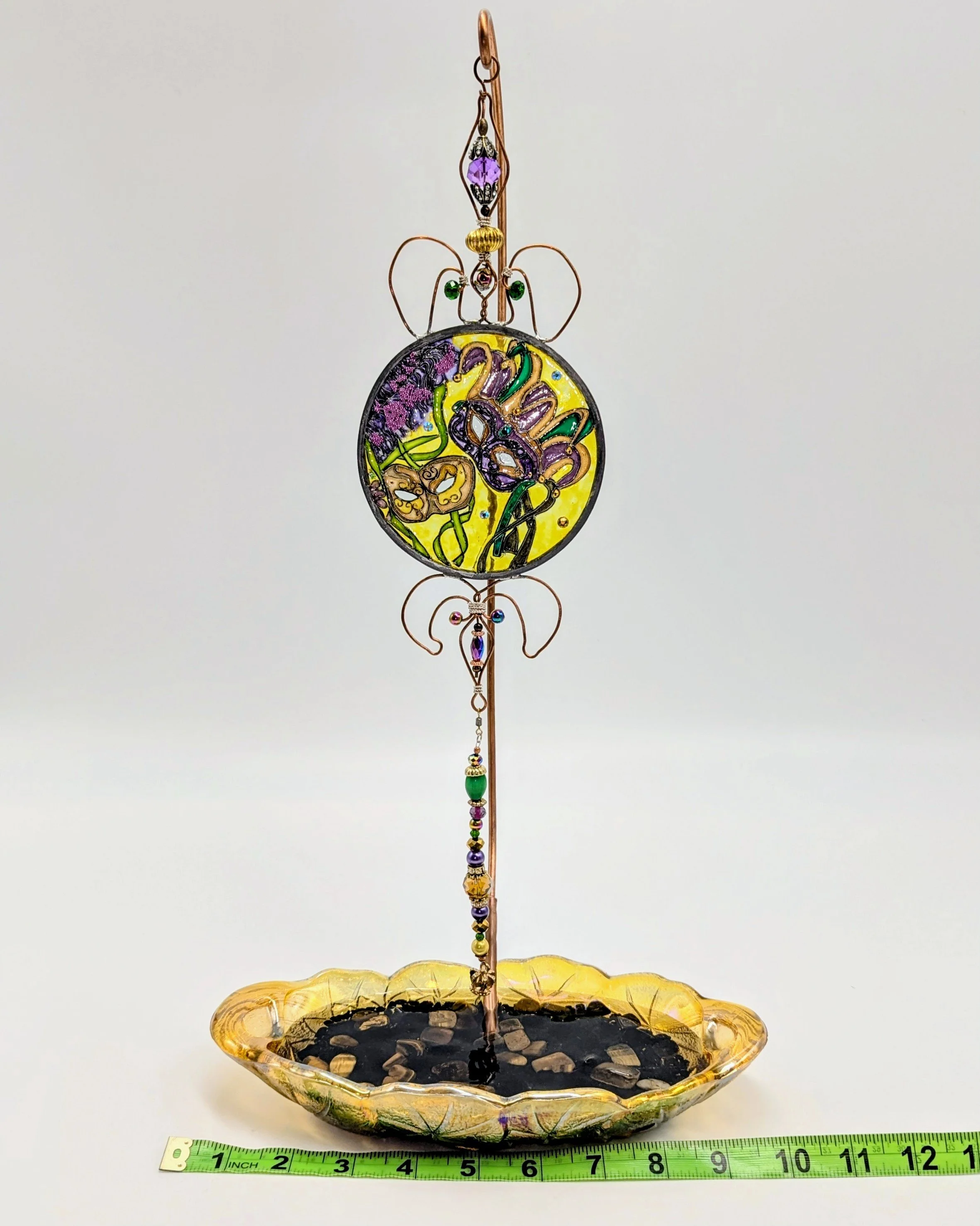 Mardi Gras Mask Illusion Glass on Golden Carnival Glass Stand
This elegant display stand features a beautiful antique-style golden Carnival Glass scalloped base paired with a tall, gracefully curved copper rod. It is shown here supporting a vibrant M