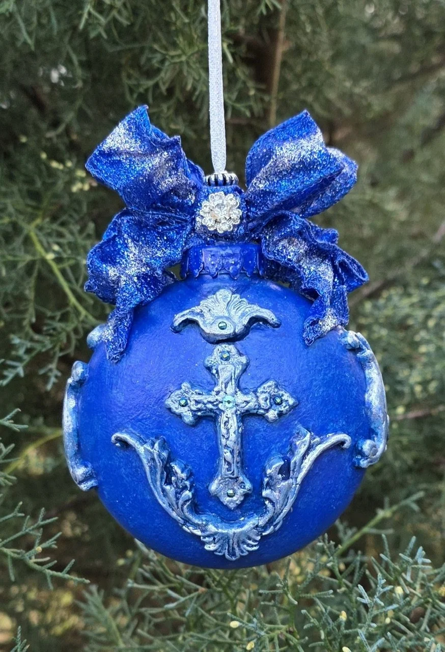 Close-up front view of the Celestial Blue Cross Ornament by Art Illusions by Young. The luminous cobalt blue surface and ornate silver cross with filigree detailing are highlighted from this perspective, enhanced with turquoise European crystal embel