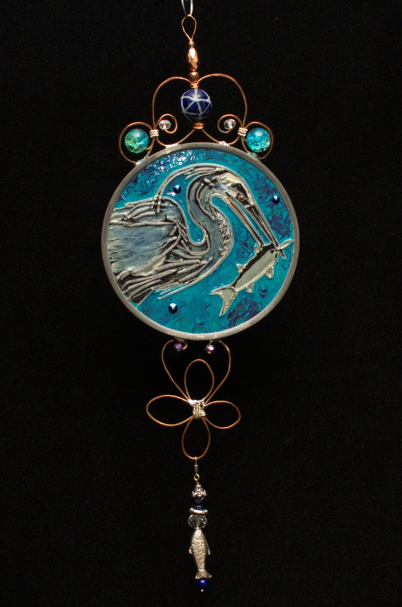 Blue Heron by Art Illusions by Young against a dark background. A majestic Great Blue Heron stands poised in mid-catch, elegantly capturing a large fish in this hand-painted and leaded Illusion Glass panel. The dark backdrop dramatically highlights t
