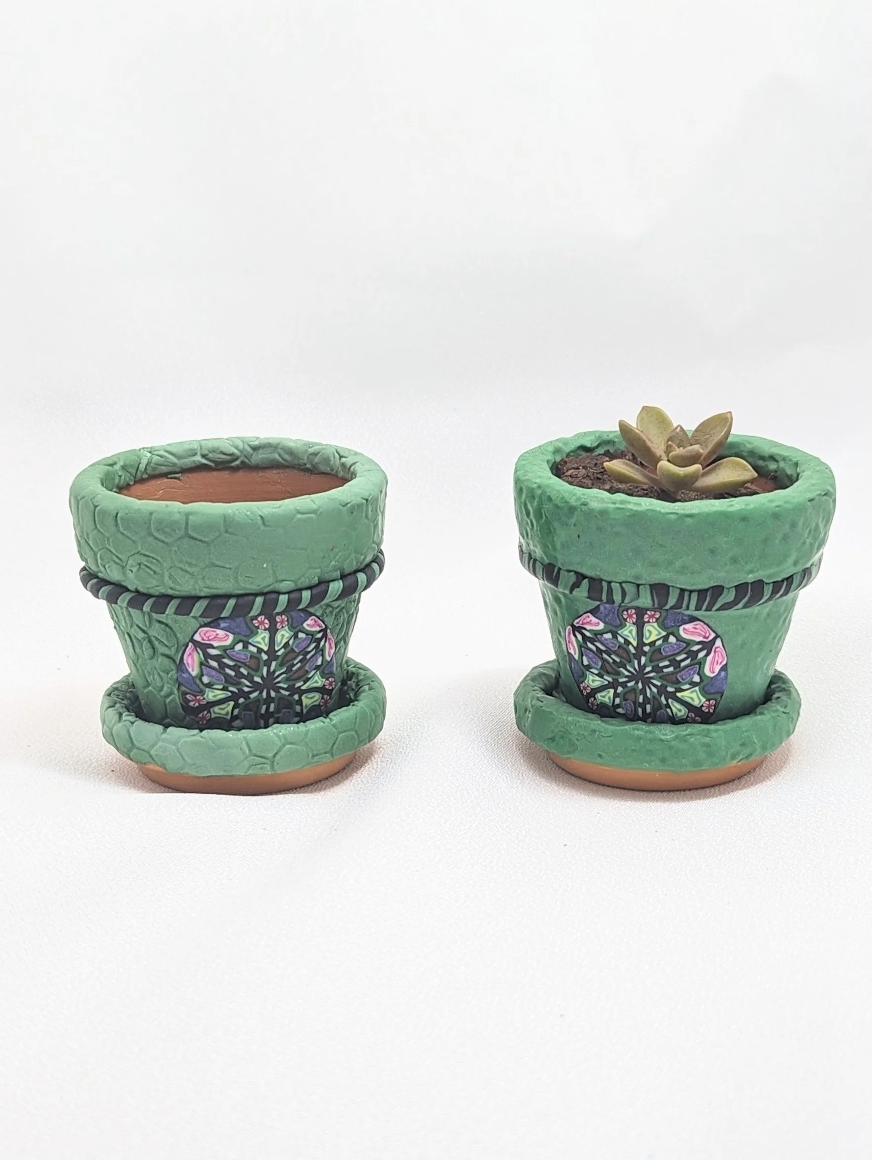 Close-up view of two coordinating green Mardi Gras micro clay pots, highlighting the beautiful hand-textured details and festive accents of these Louisiana handmade miniature planters. The left pot features a scaled, alligator-skin texture on the rim