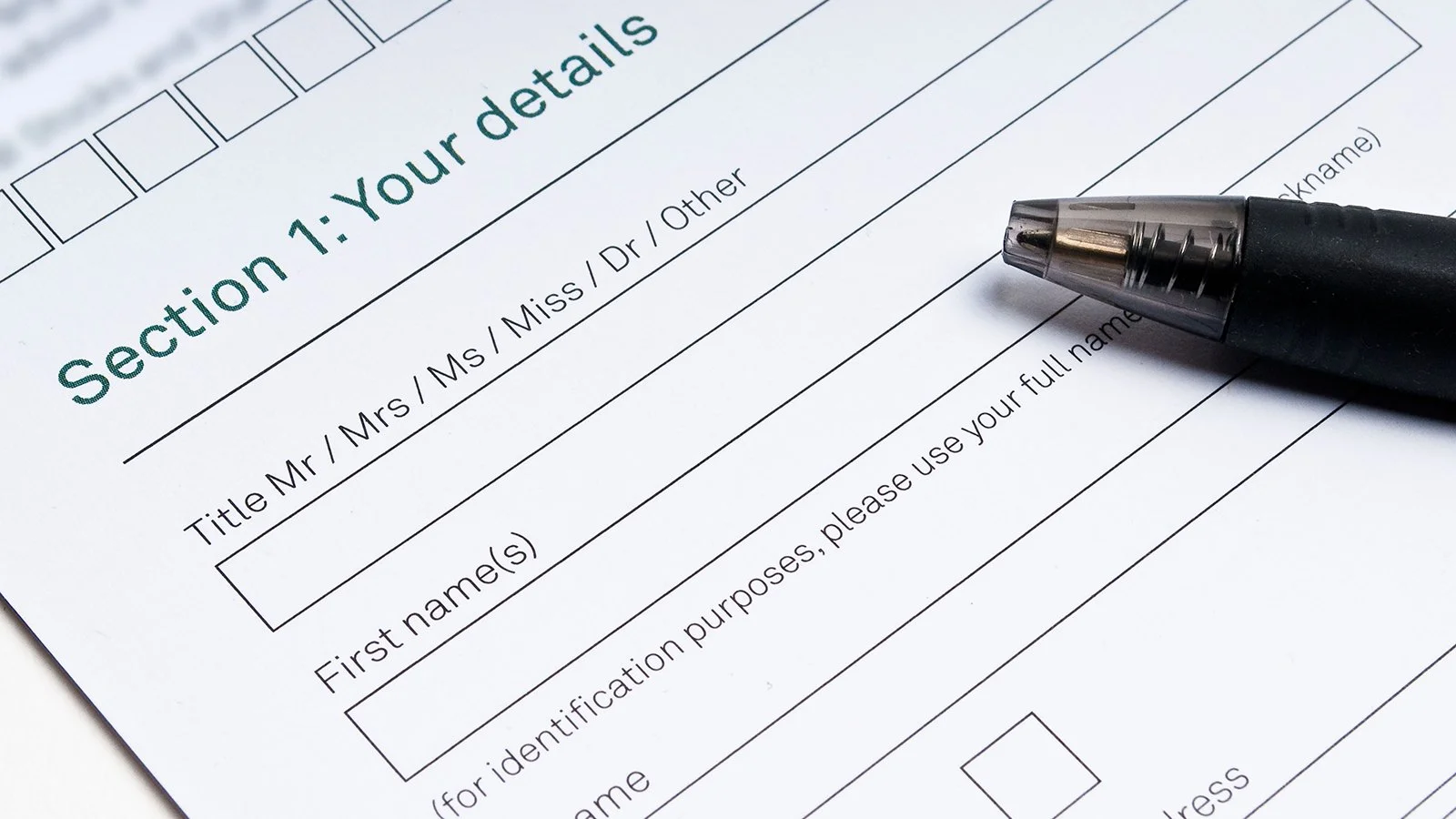 A blank form titled 'Section 1: Your details' with fields for name and identification purpose, partially filled with a black pen.