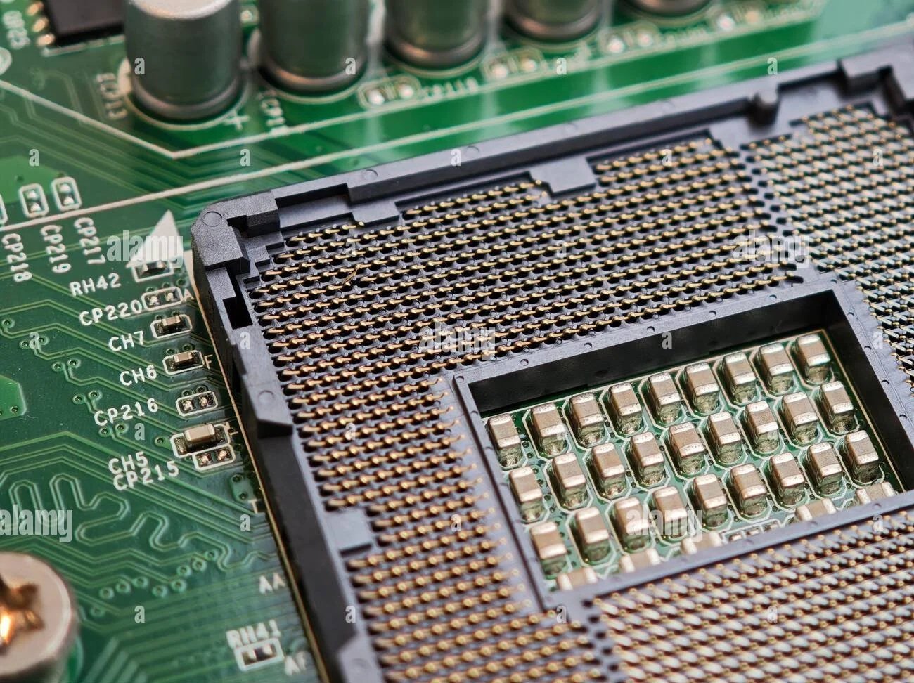 Close-up of a computer motherboard with a CPU socket and various electronic components.