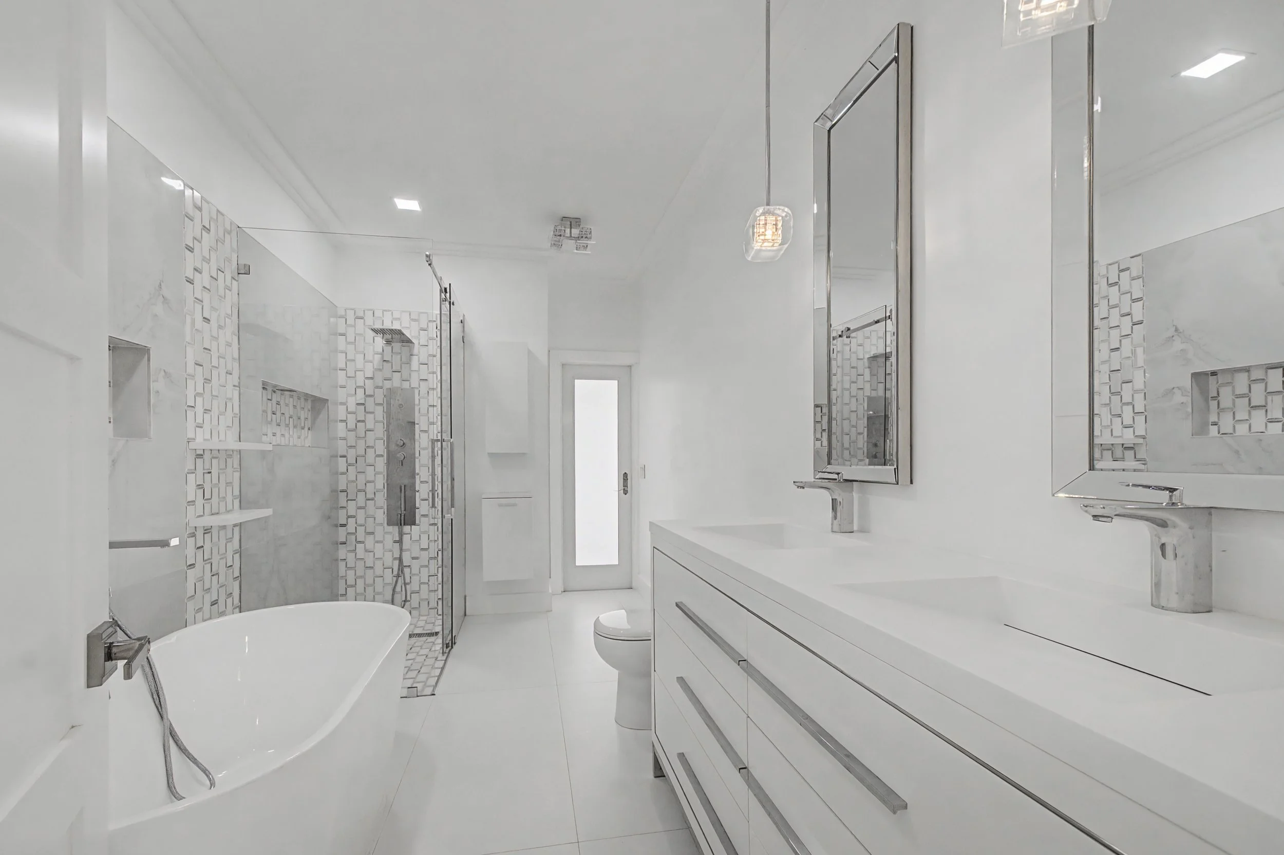 Modern white bathroom with a bathtub, a glass-enclosed shower, white cabinetry, and mirrors.