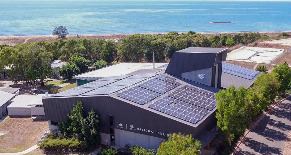 Building with solar panels on roof near a beach, labeled 'National Sea'.