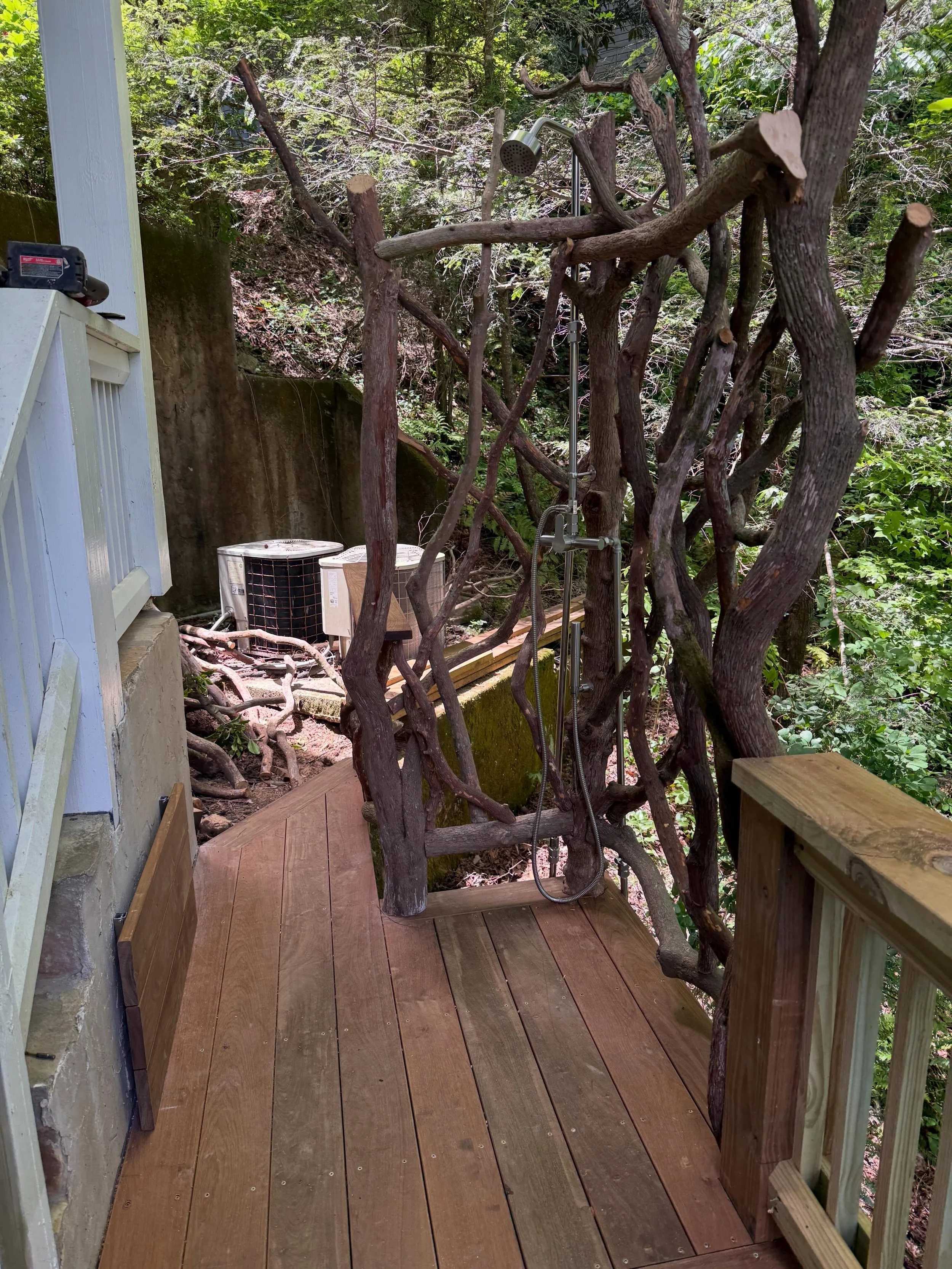 Outdoor shower with under deck drain, bench, and mountain laurel walls!