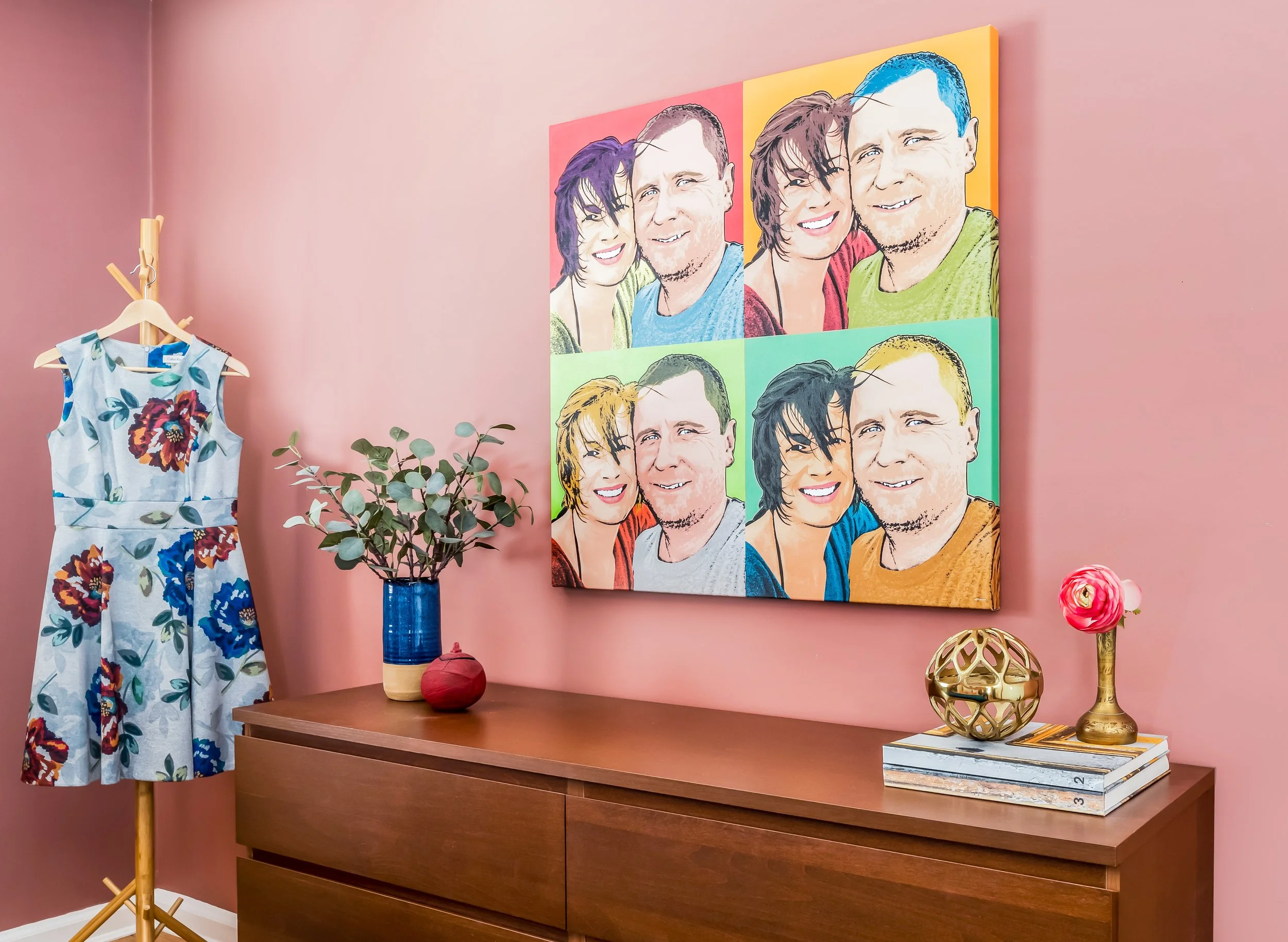 Colorful bedroom featuring custom family artwork, warm coral walls, layered textiles, and thoughtfully styled décor.