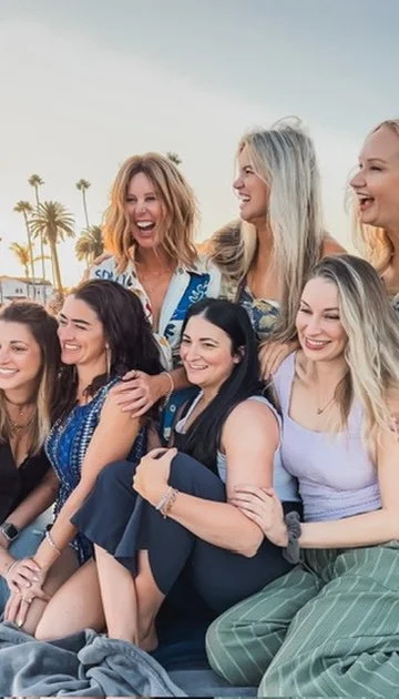 City Living Network editors smiling and laughing outdoors with palm trees in the background.