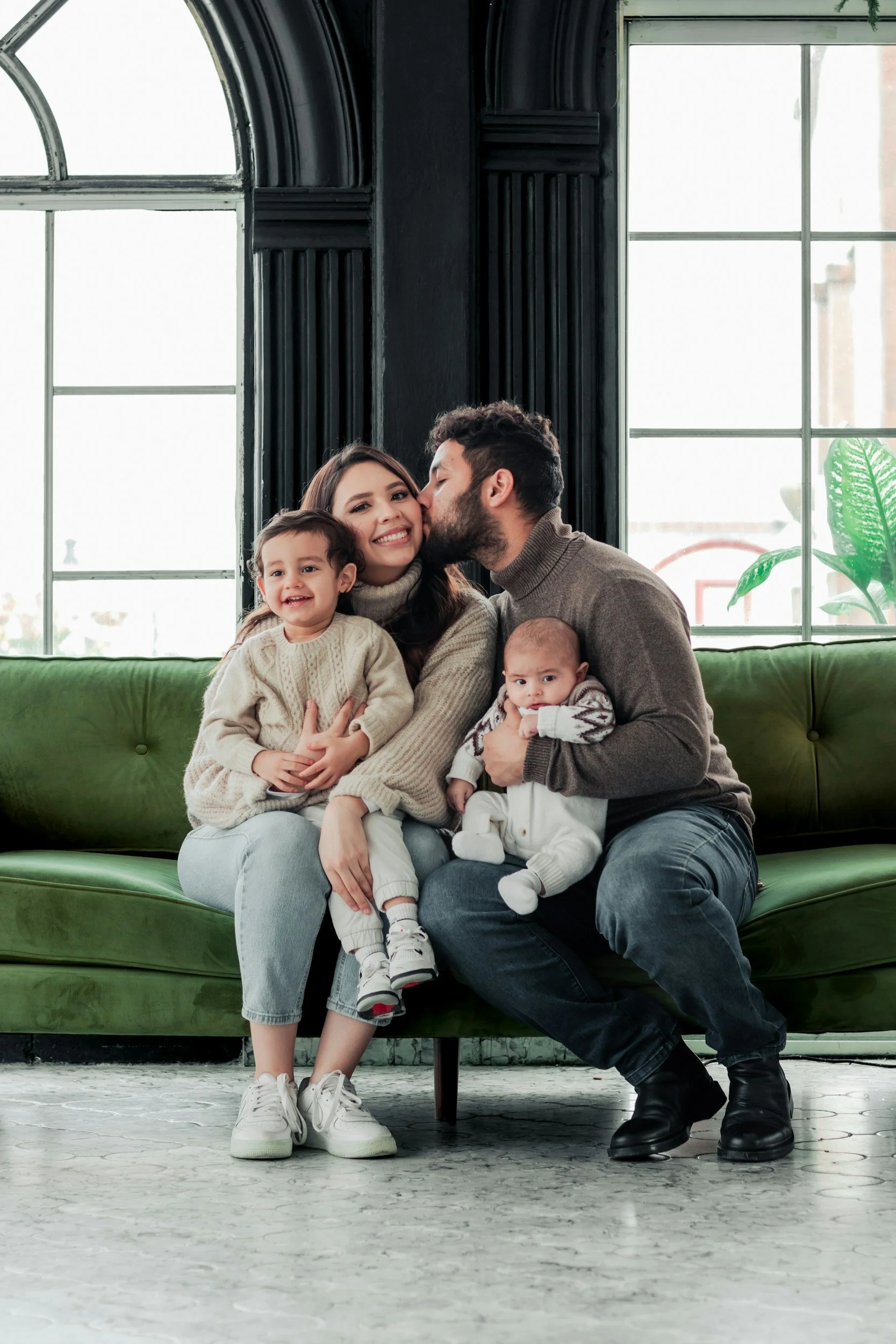 Family with two parents and two young children spending time together, representing supportive parenting, family learning, child development, and strong family relationships.