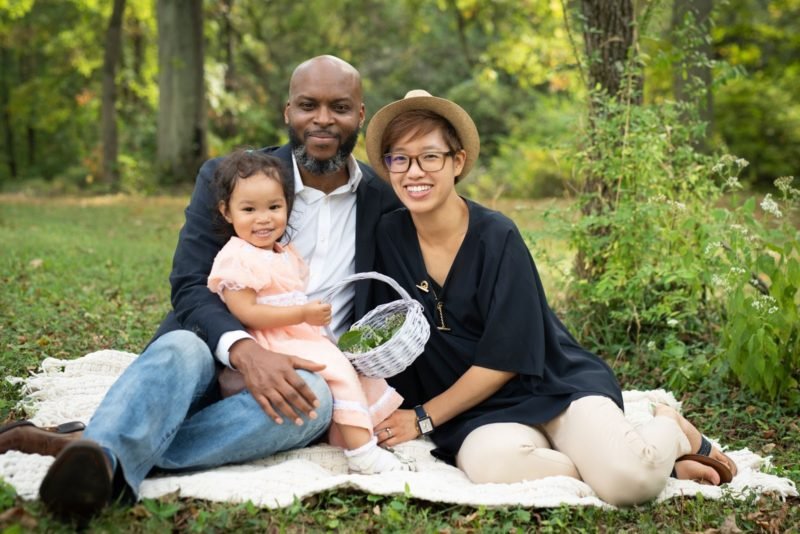 Multiracial family enjoying time together outdoors, representing healthy child development, positive parenting, family well-being, and lifelong learning.