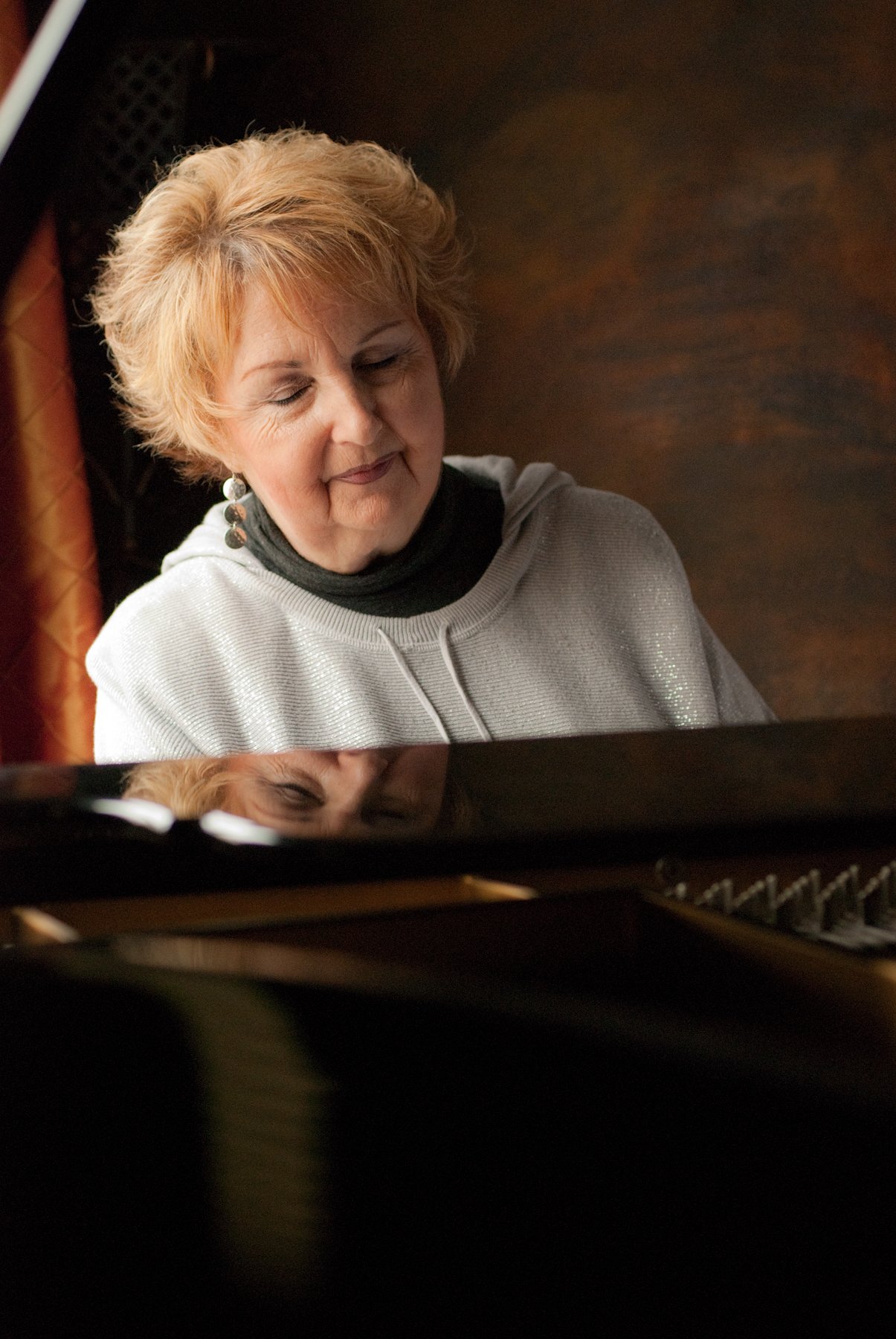 A close up of marlene playing her piano
