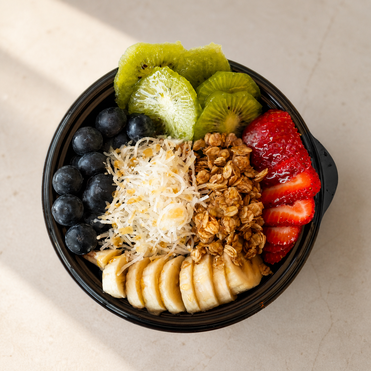 Andias açaí bowl topped with fresh fruit and granola