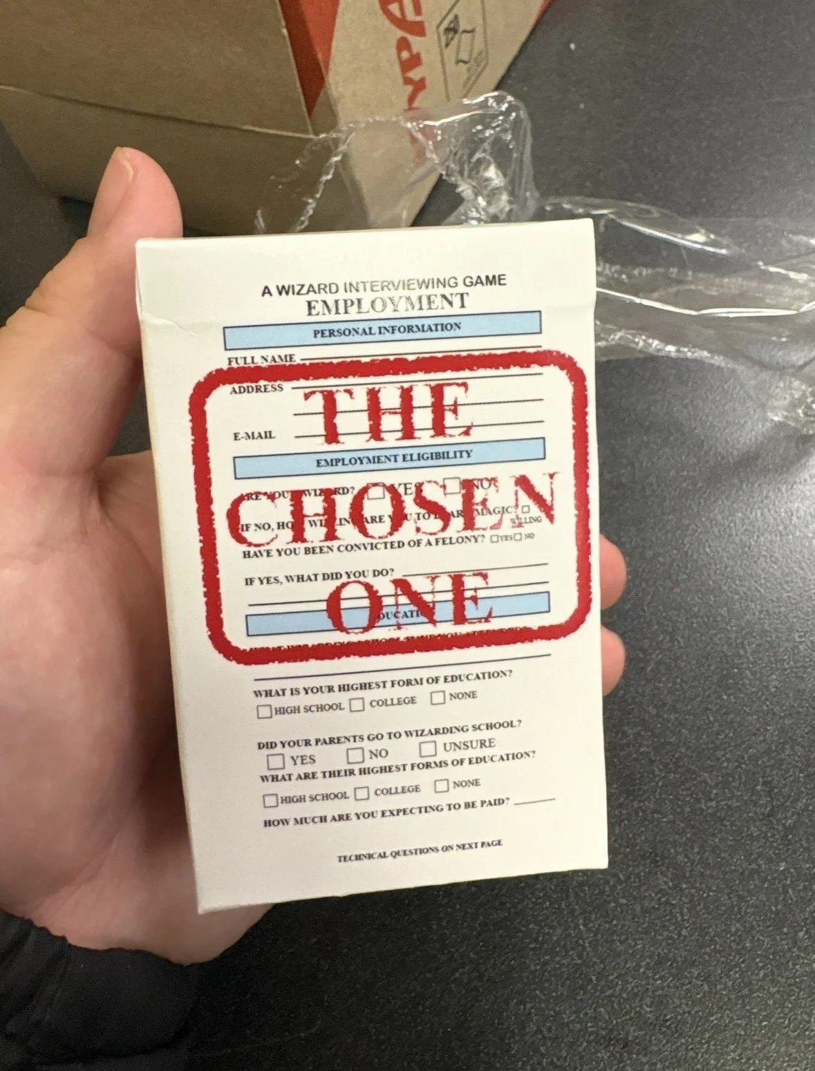 The box design of The Chosen One! I designed it based off of a real-life job application, changing the questions to be more wizard related. The physical box was ordered on The Game Crafter website, and I think it came out really nice.