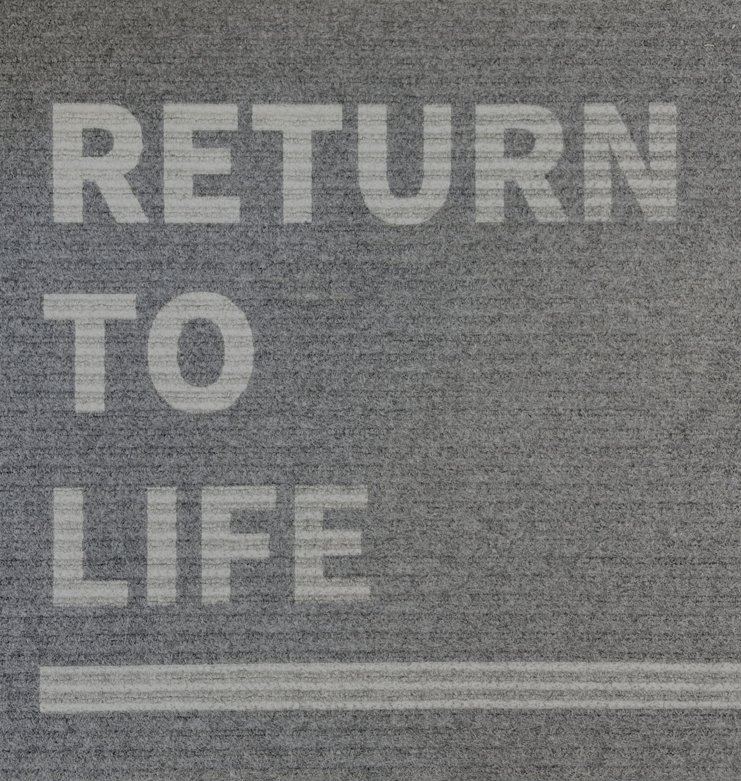 Close-up of a textured gray surface with the word 'RETIRED' painted in white letters.