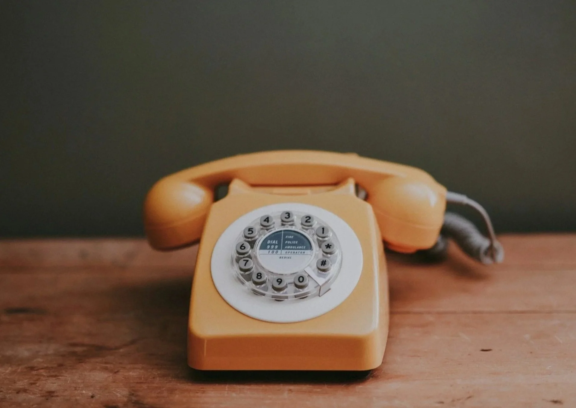Téléphone fixe orange vintage sur une surface en bois