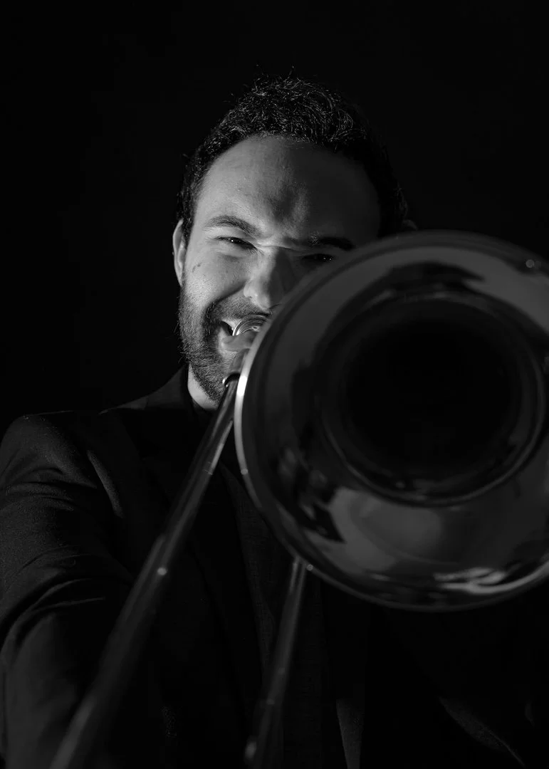 Hombre tocando el trombón en un montaje en blanco y negro.