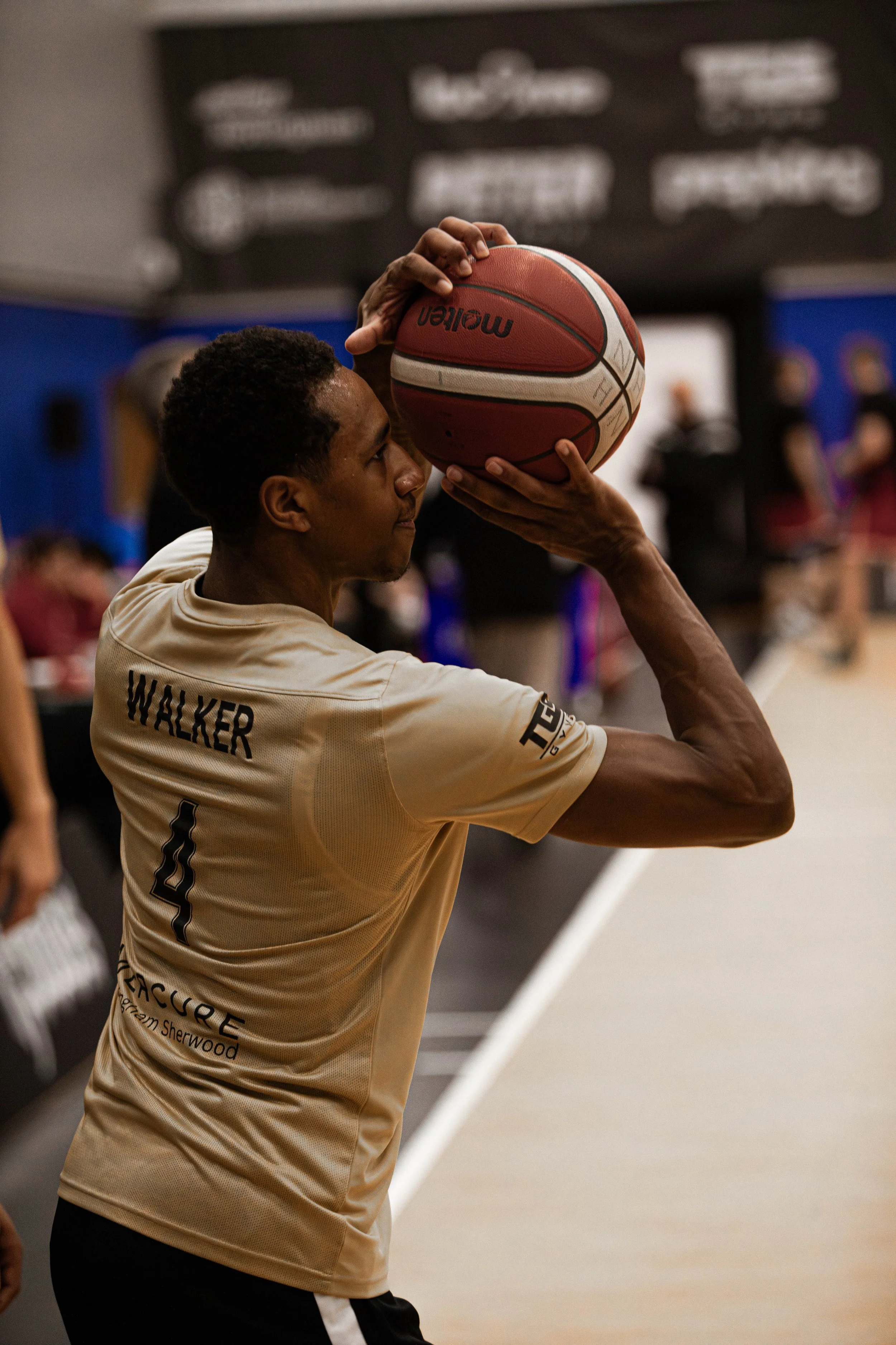 A person wearing a beige basketball jersey with the name 'Walker' and the number 4, preparing to shoot a basketball during a game or practice in an indoor gym.