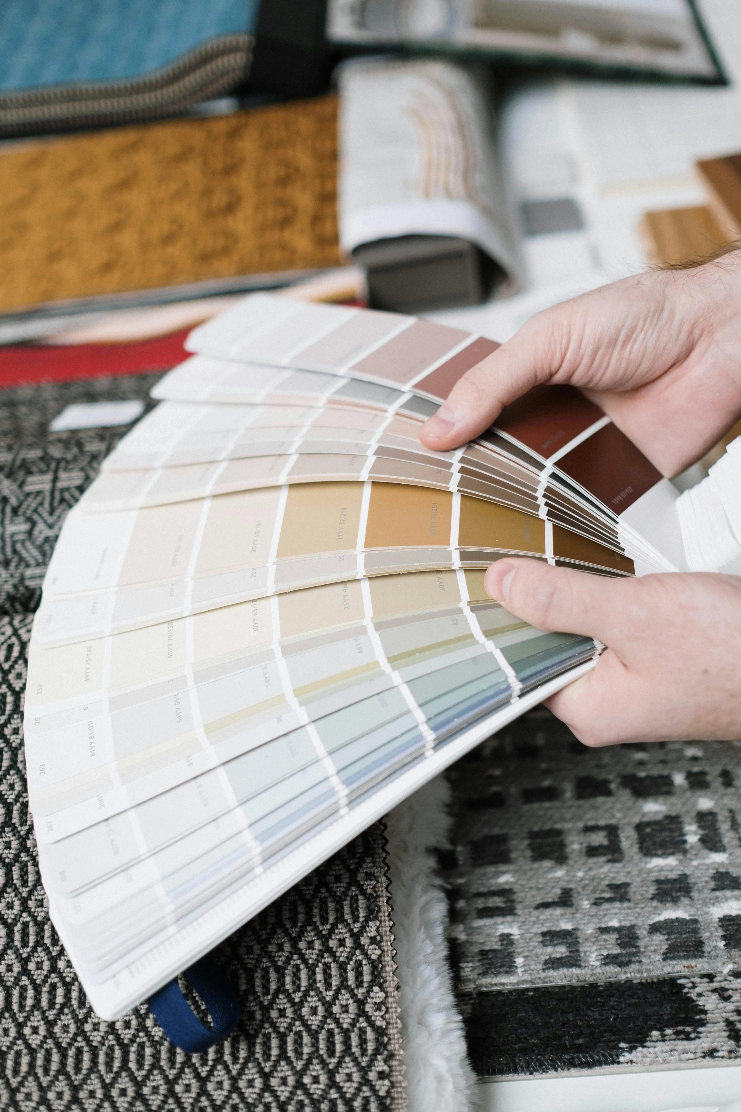 Person holding a fan deck of paint color swatches.