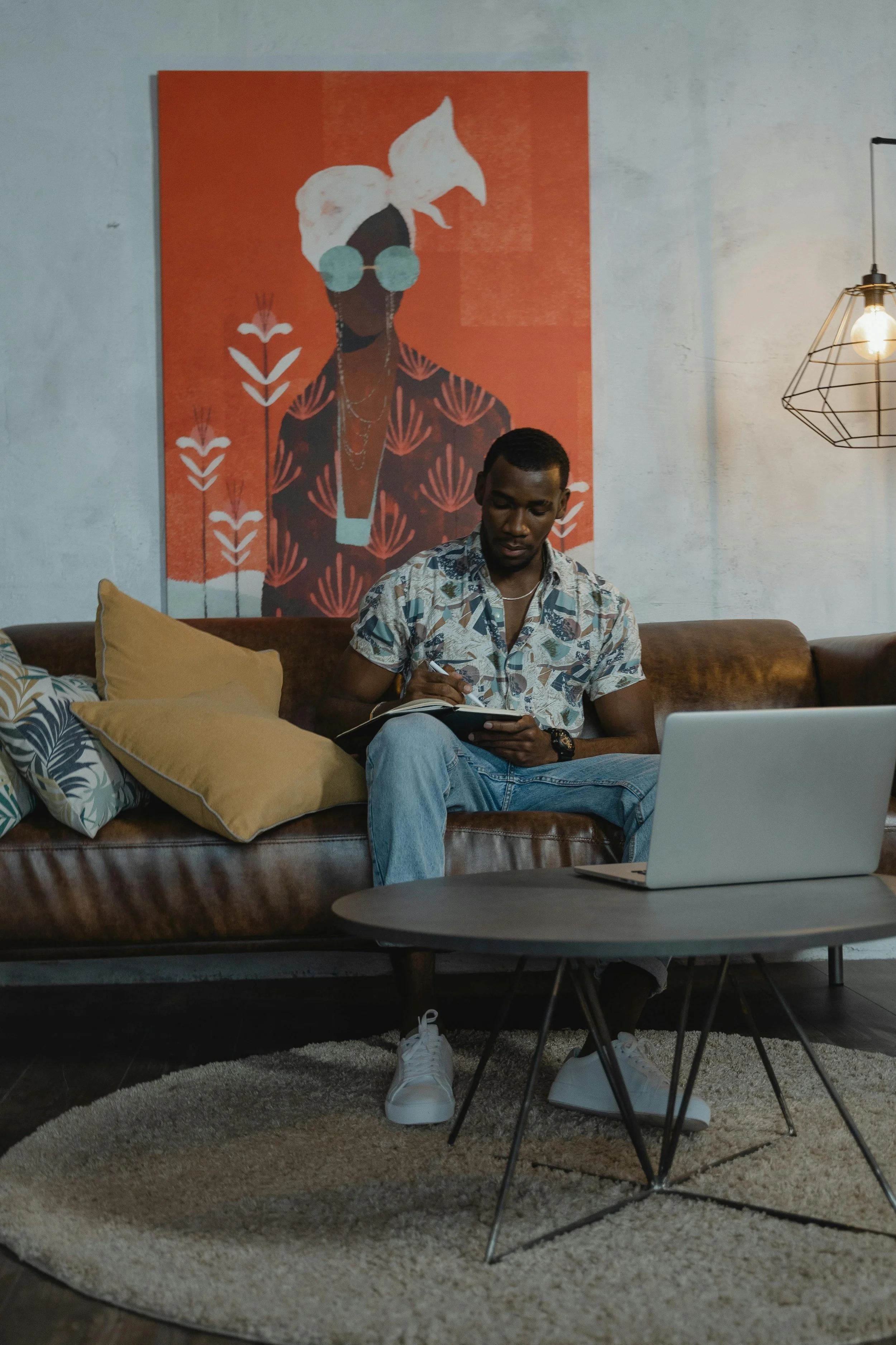 A man sitting relaxed on a couch with a laptop, representing ADHD and burnout therapy for adults in Connecticut