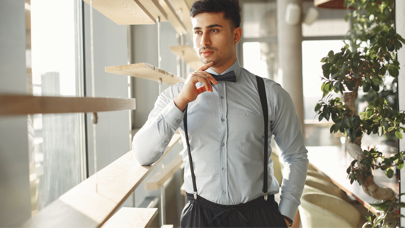 A man in formal attire standing and looking thoughtful, representing high-functioning burnout therapy in Connecticut