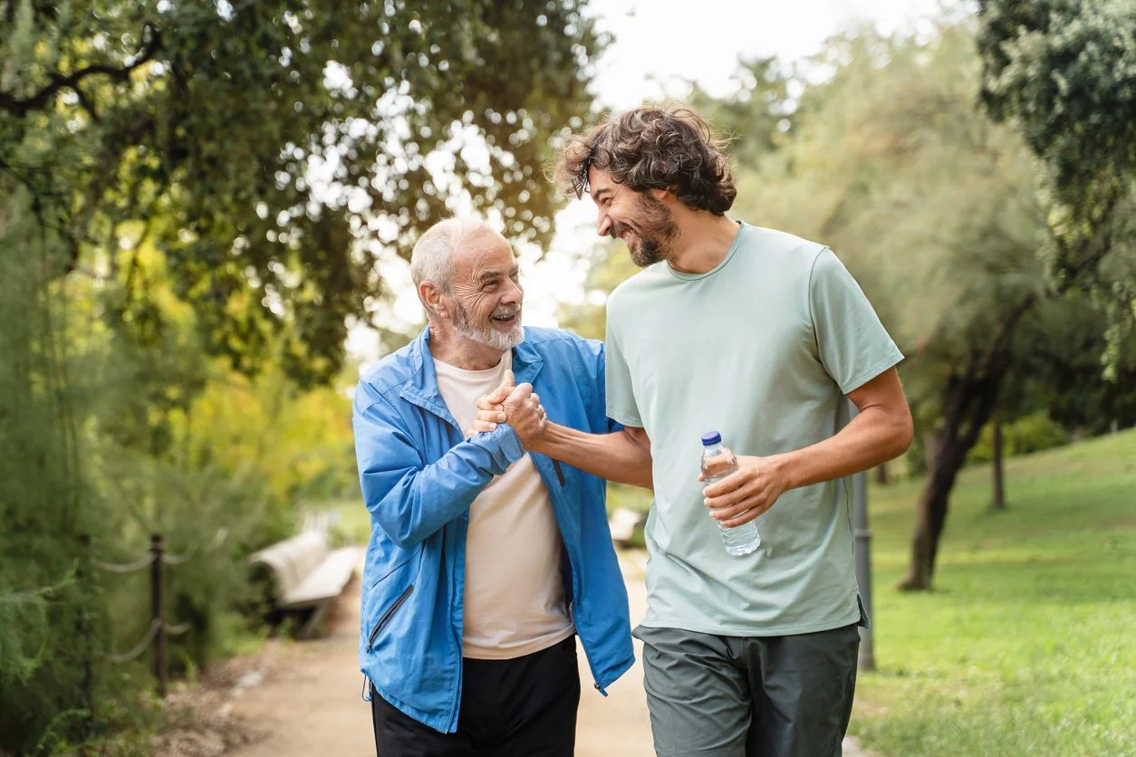 Two men walking outdoors together laughing, representing identity and boundaries therapy in Connecticut