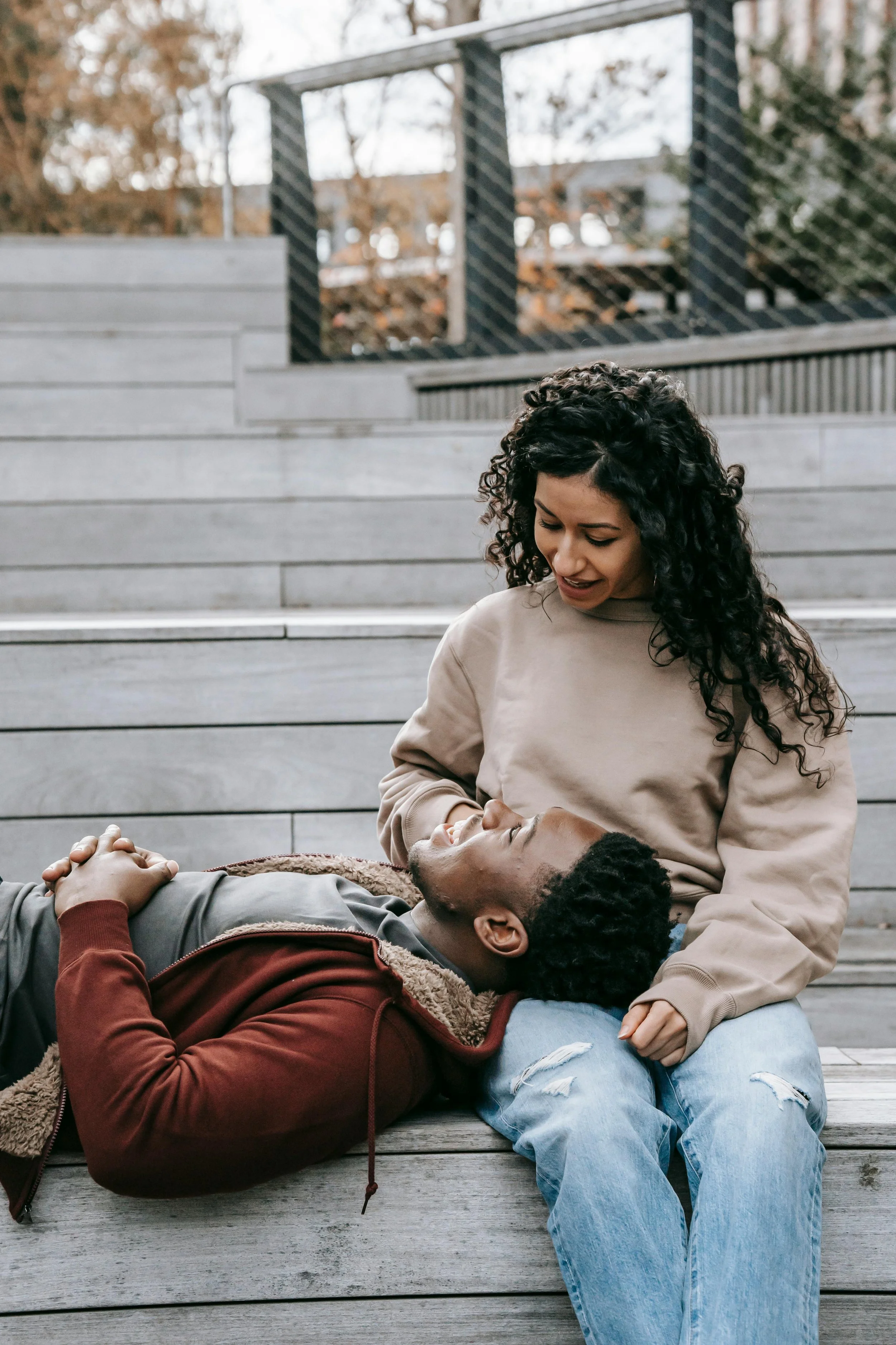 A couple sitting on outdoor steps together, the woman resting on the man's shoulder, representing honest and supportive couples counseling in Meriden, CT