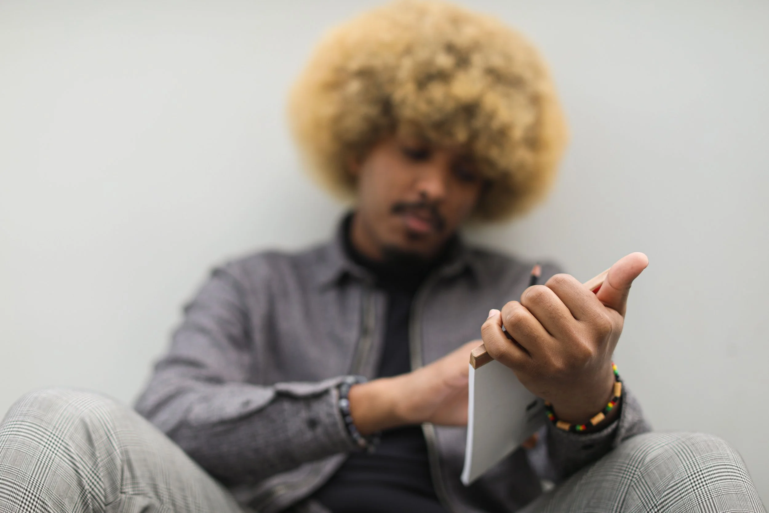 A woman holding a pencil and open journal with a calm expression, representing the early stages of burnout recovery through therapy in Connecticut
