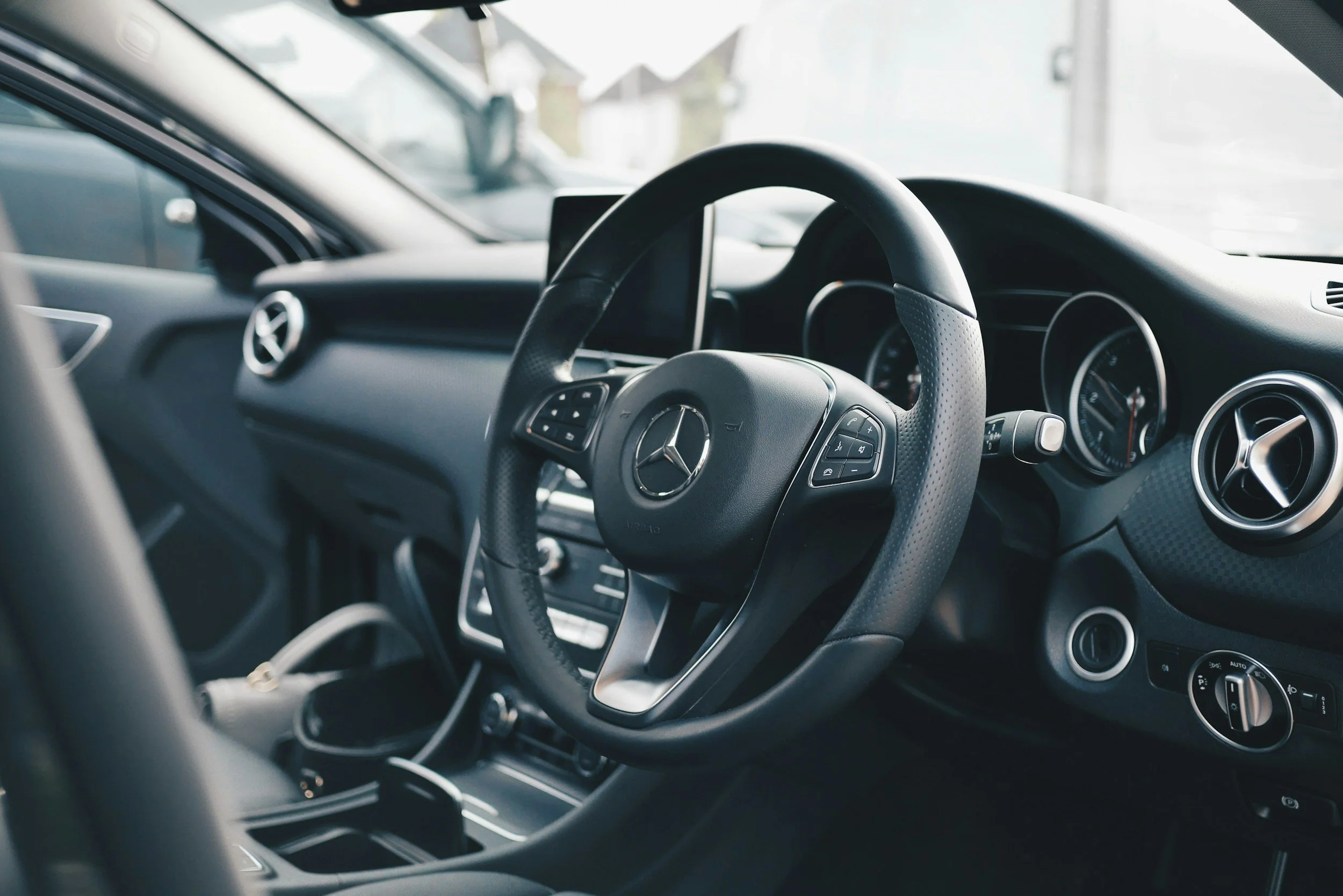 Interior of a Mercedes-Benz after a detail focusing on the cleanliness of the steering wheel and dashboard.