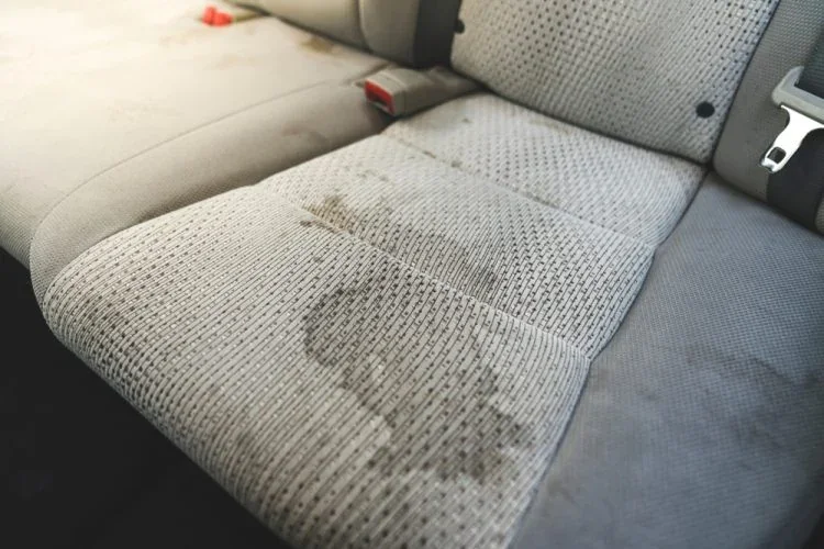 Car seat with visible heavy stains on the fabric.