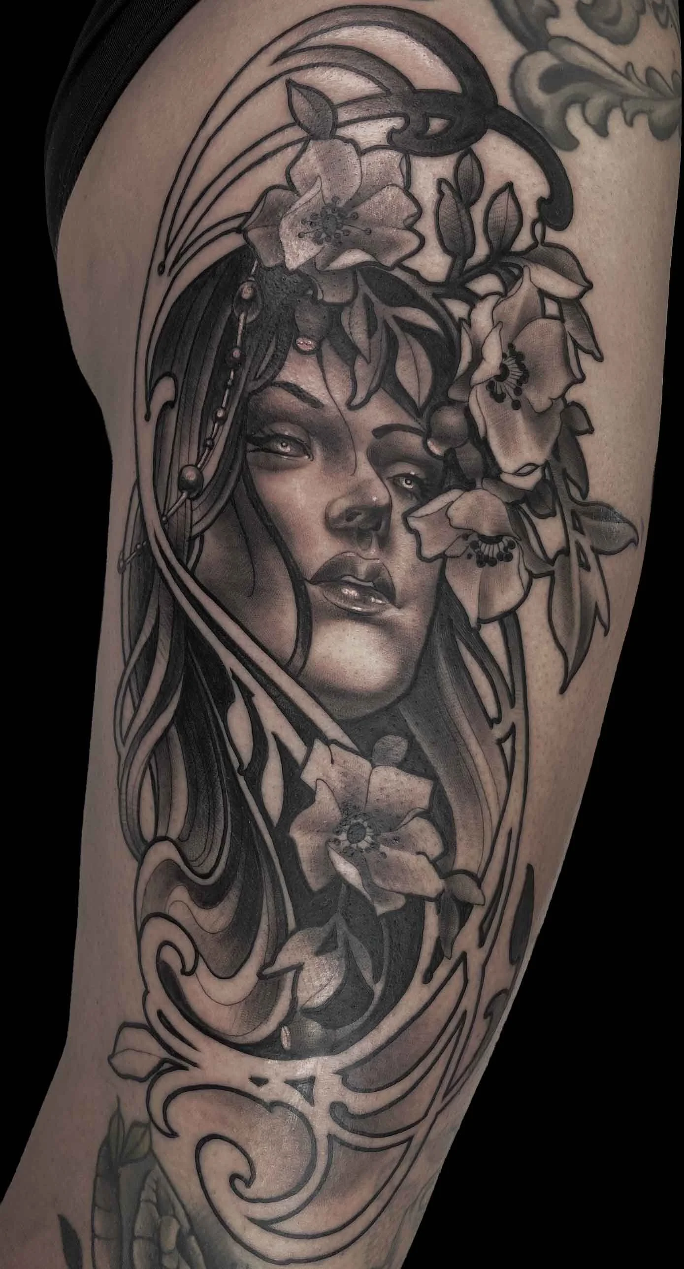 A black and grey neotraditional portrait of a pretty lady adorned by art nouveau elements and florals