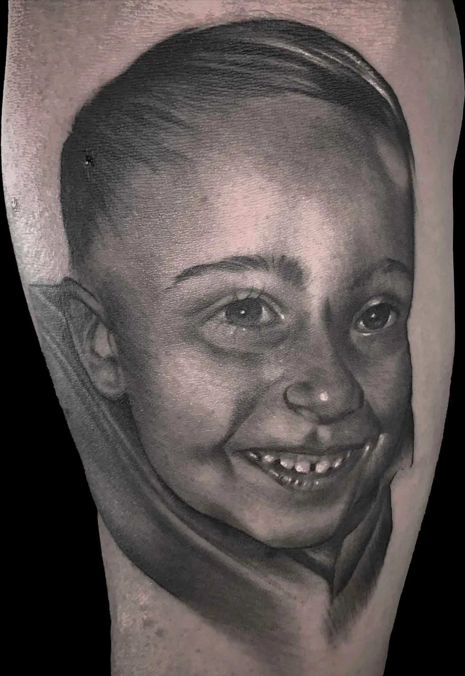 a smooth realistic black and grey portrait tattoo of a young boy and son