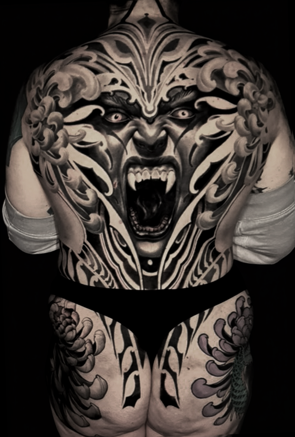 Ornamental, black and gray style back tattoo of a vampire and chrysanthemum flowers in Nova decorative ornamental tattoo style by Jewp