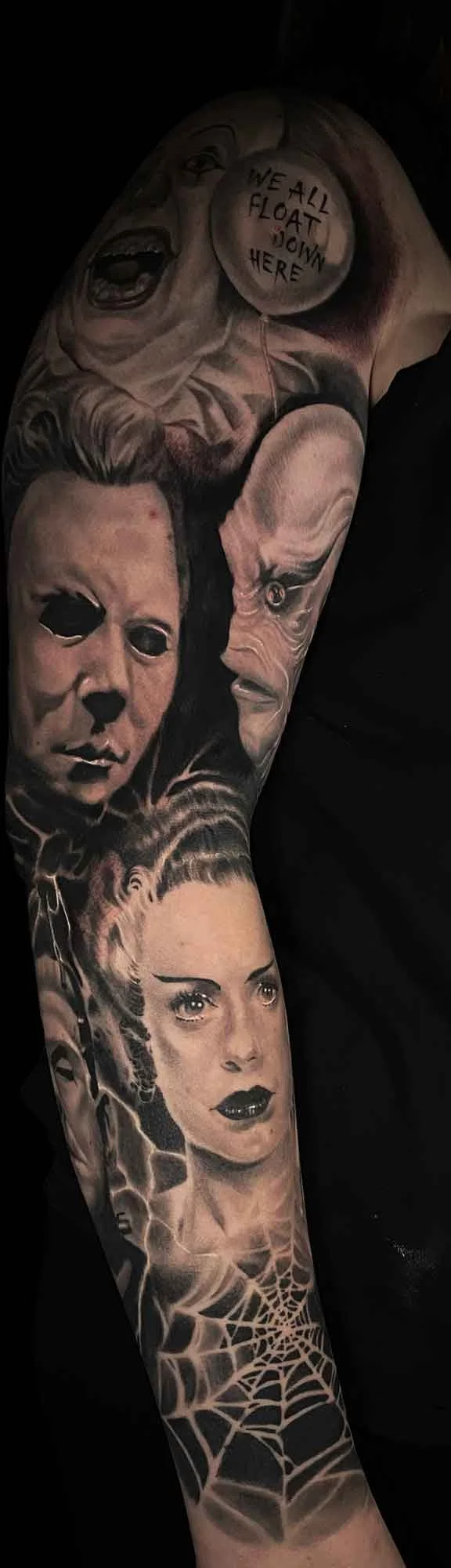 a black and grey arm sleeve horror portrait tattoo featuring the creature from the black lagoon, Frankenstein's bride, Michael Meyers and the original pennywise tattoo by Jewp