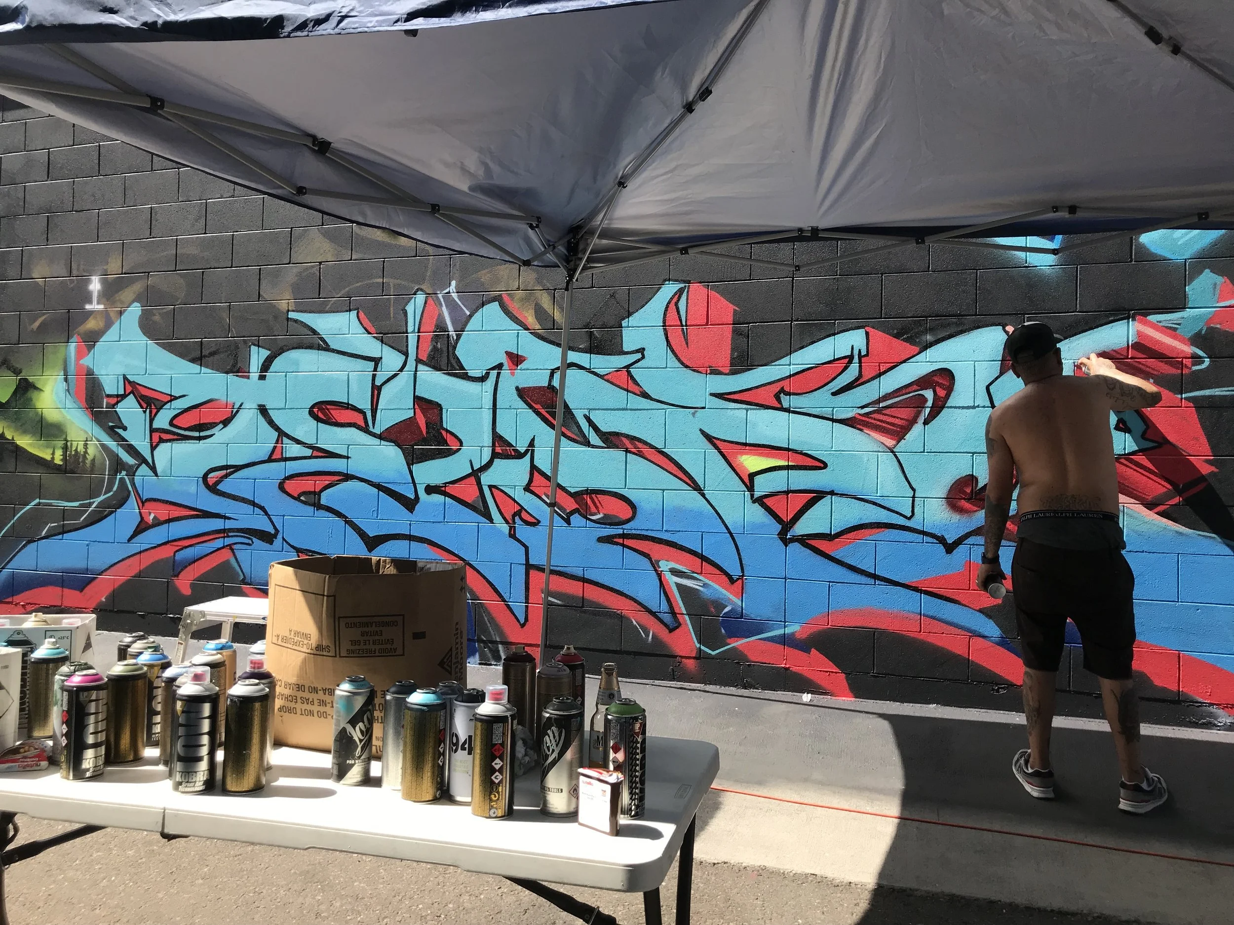 Jewp paints a burner wit RTD crew at Colorado Crush annual Mural Jam in Denver's RiNo neighborhood