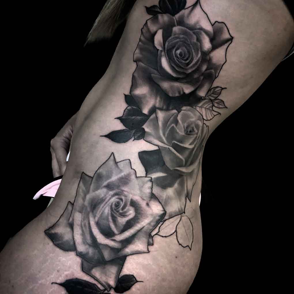 three beautiful roses placed on a woman's hip in a black and grey realism style